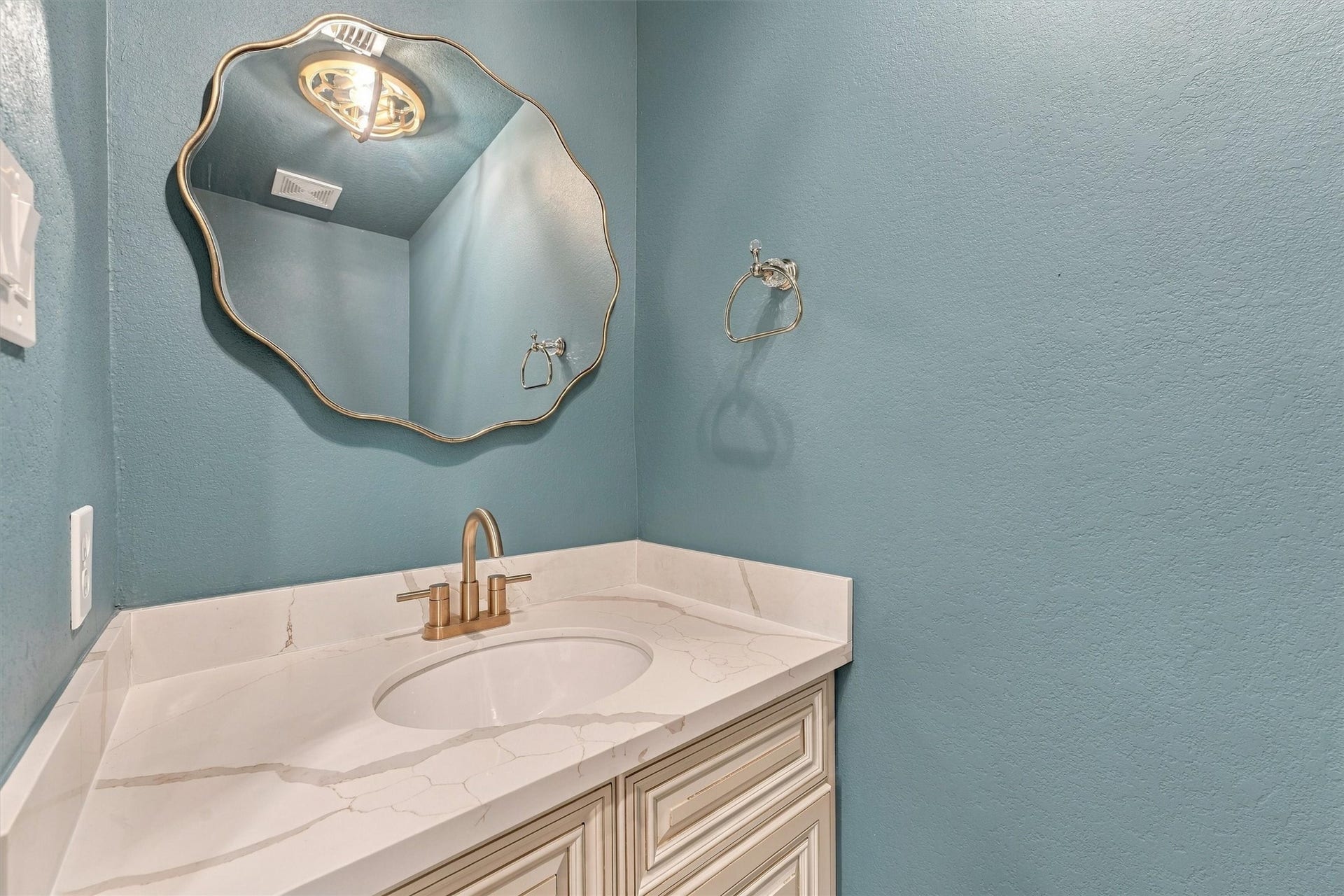 22415 Elizabeth Place Court, Katy, TX 77494 Downstairs half bath with teal walls, decorative mirror, and vanity.
