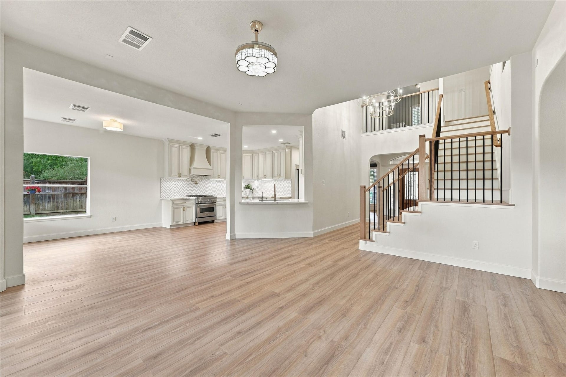 22415 Elizabeth Place Court, Katy, TX 77494 Open living area with wood flooring, abundant natural light, staircase, and open flow to the kitchen and dining areas.