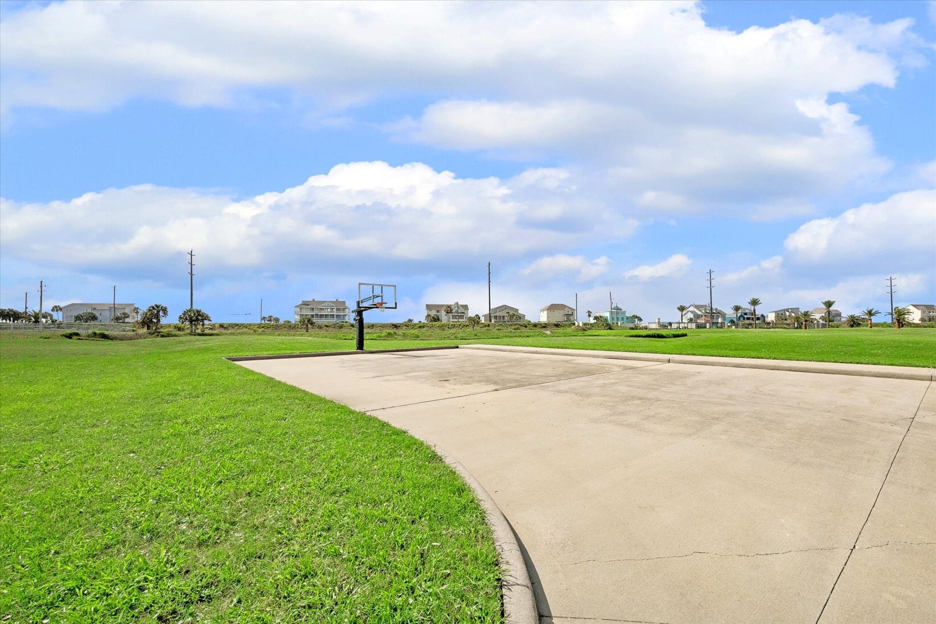 21205 Scissor Tail Lane, Galveston, TX 77554 Basketball court access adds another easy way to enjoy the outdoors within Sunset Cove. Open green space and coastal homes in the distance keep the setting relaxed and neighborhood-focused.