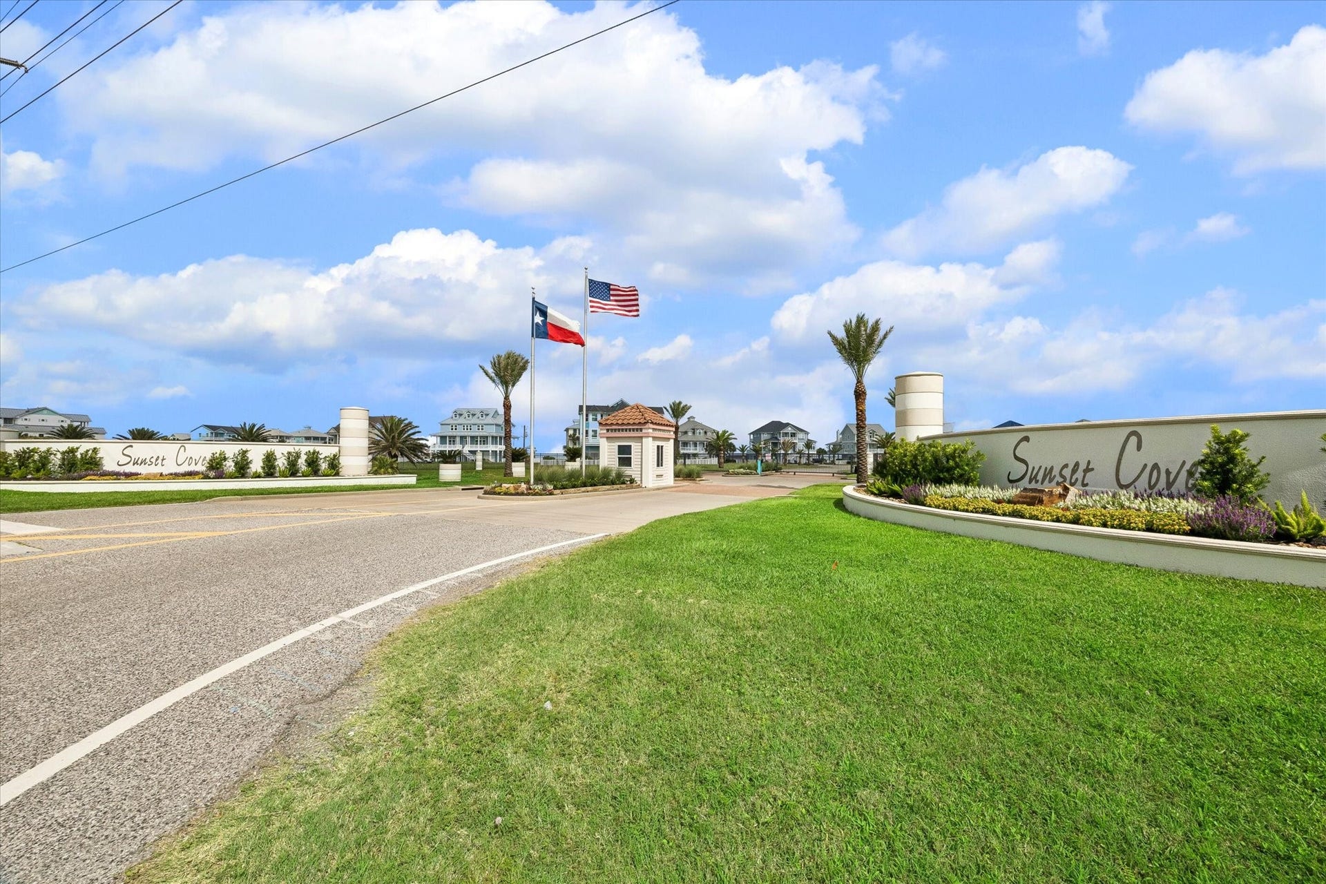 21205 Scissor Tail Lane, Galveston, TX 77554 The Sunset Cove entrance sets the tone with gated access, landscaped signage, and a polished coastal arrival. Palm-lined streets lead into a private neighborhood designed around water access and relaxed beachside living.