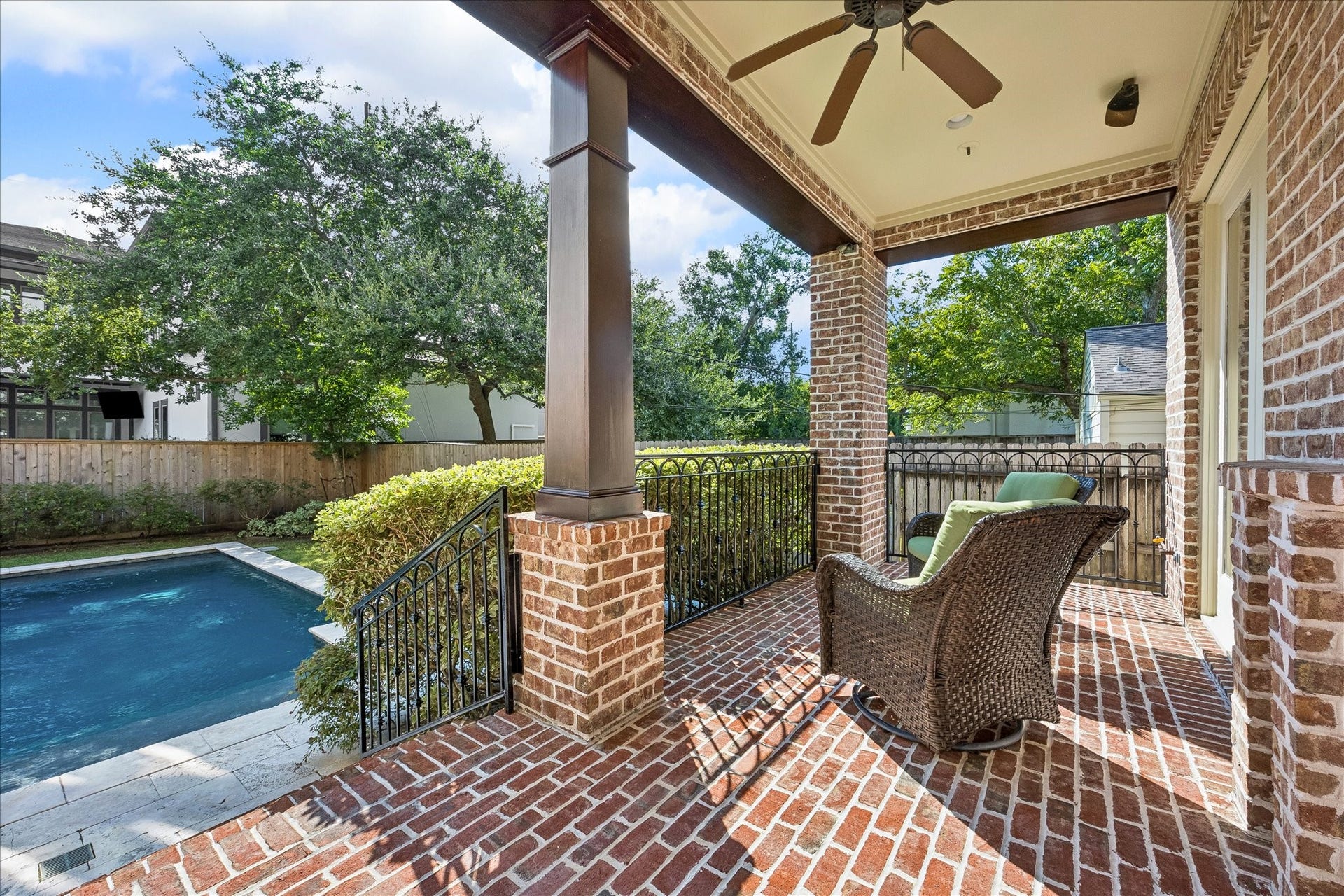 4037 Dumbarton Street, Houston, TX 77025 Charming covered patio with brick accents overlooks a serene pool, perfect for relaxing or entertaining.