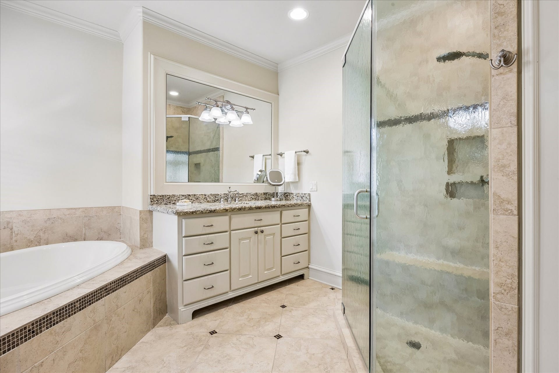 4037 Dumbarton Street, Houston, TX 77025 The generously sized bathroom features a spacious glass-enclosed shower, a luxurious soaking tub, and a stylish double vanity with sitting area.