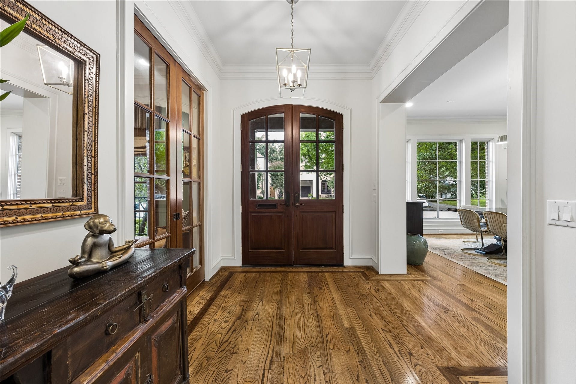 4037 Dumbarton Street, Houston, TX 77025 Inviting entryway with rich hardwood floors, a striking double wooden front door, and abundant natural light from large windows, creates a warm and welcoming atmosphere.