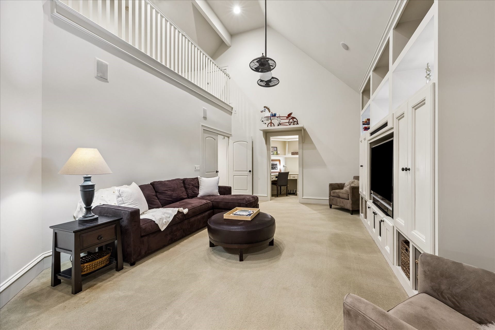 4037 Dumbarton Street, Houston, TX 77025 Spacious game room with vaulted ceilings, features a built-in entertainment center and explanisve seating, complemented by an adjacent office nook on one side, an art room/flex room on the other side, and a loft above, all for added functionality. This room has it ALL!