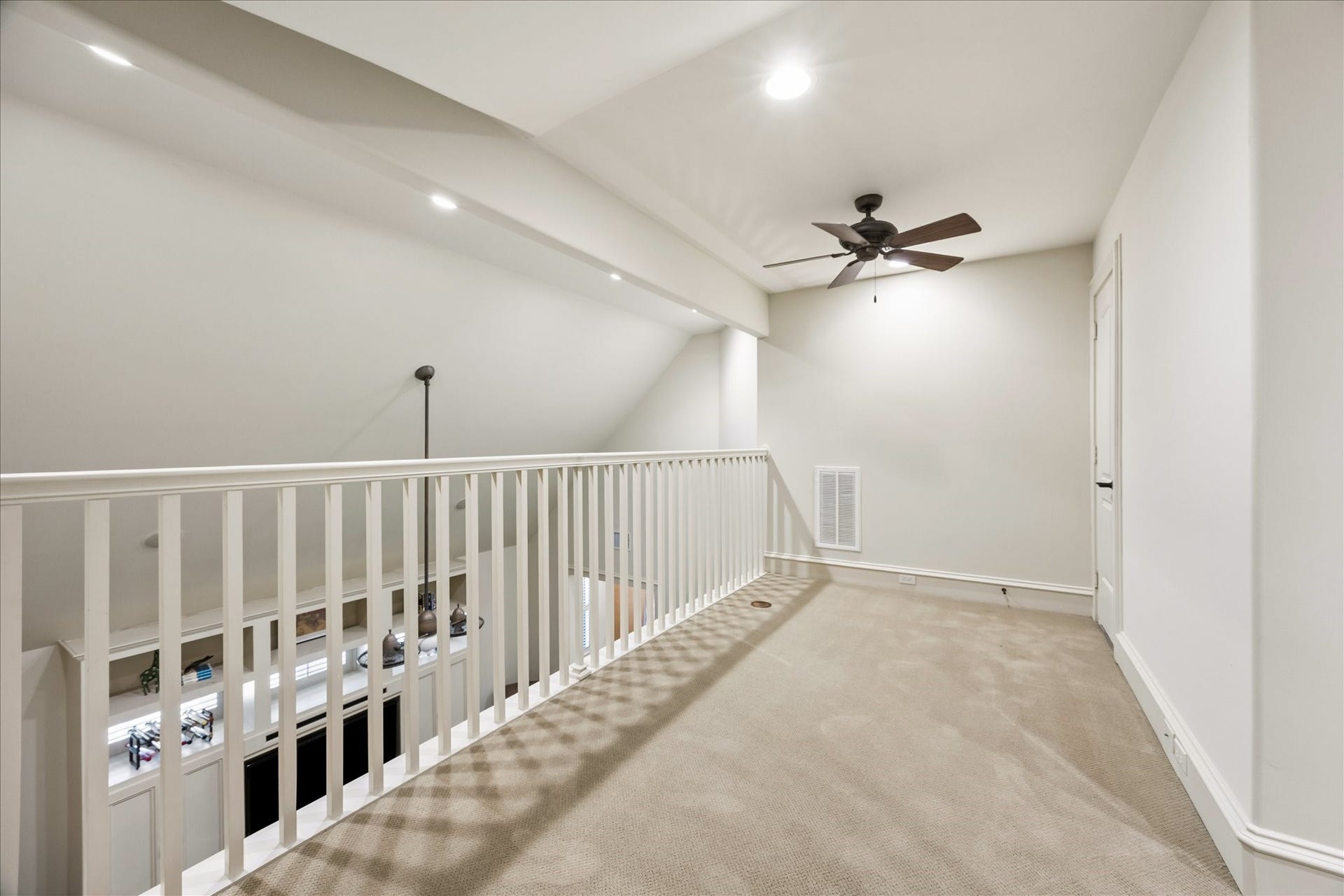 4037 Dumbarton Street, Houston, TX 77025 Spacious loft area with carpeting, ceiling fan, and open railing overlooking the game room below, perfect for a cozy reading nook or sleepovers.