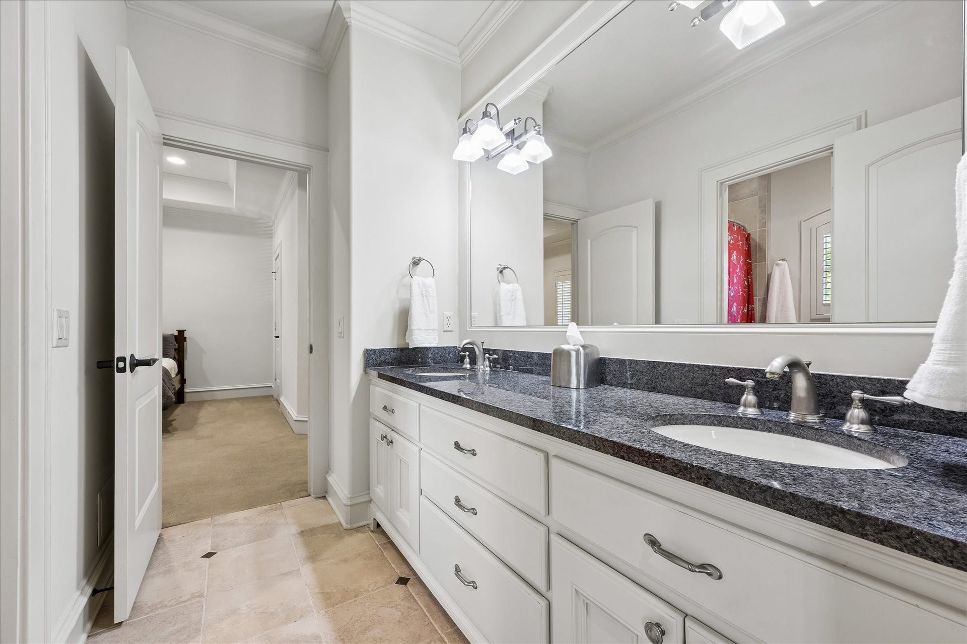 4037 Dumbarton Street, Houston, TX 77025 The Hollywood bathroom features a sleek double vanity with ample countertop space, plenty of storage, a separate tub and toilet, and seamless access to secondary bedrooms #1 and #2.