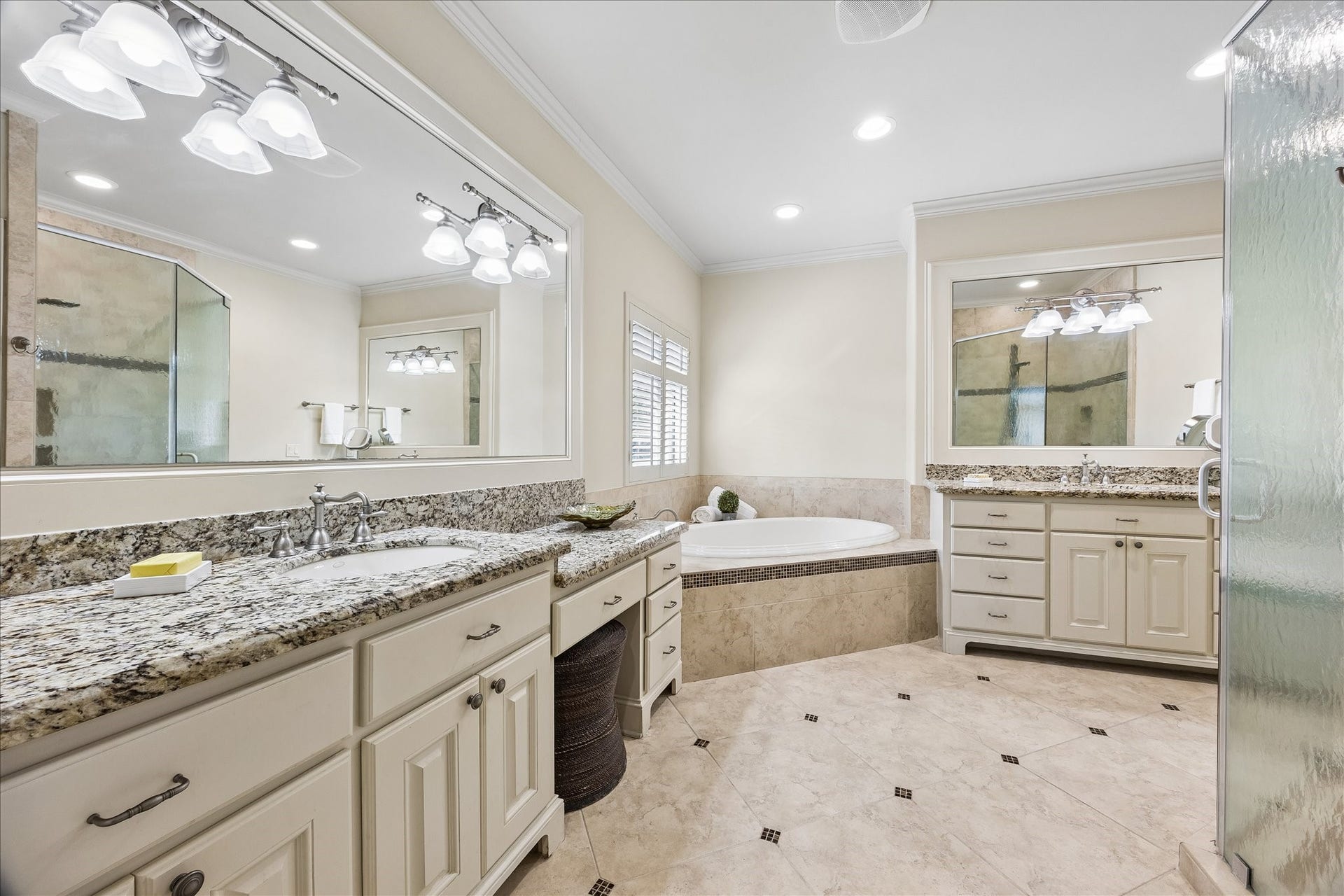 4037 Dumbarton Street, Houston, TX 77025 Luxurious bathroom featuring dual vanities, knee space for sitting area, a spacious soaking tub, and a large glass-enclosed shower.
