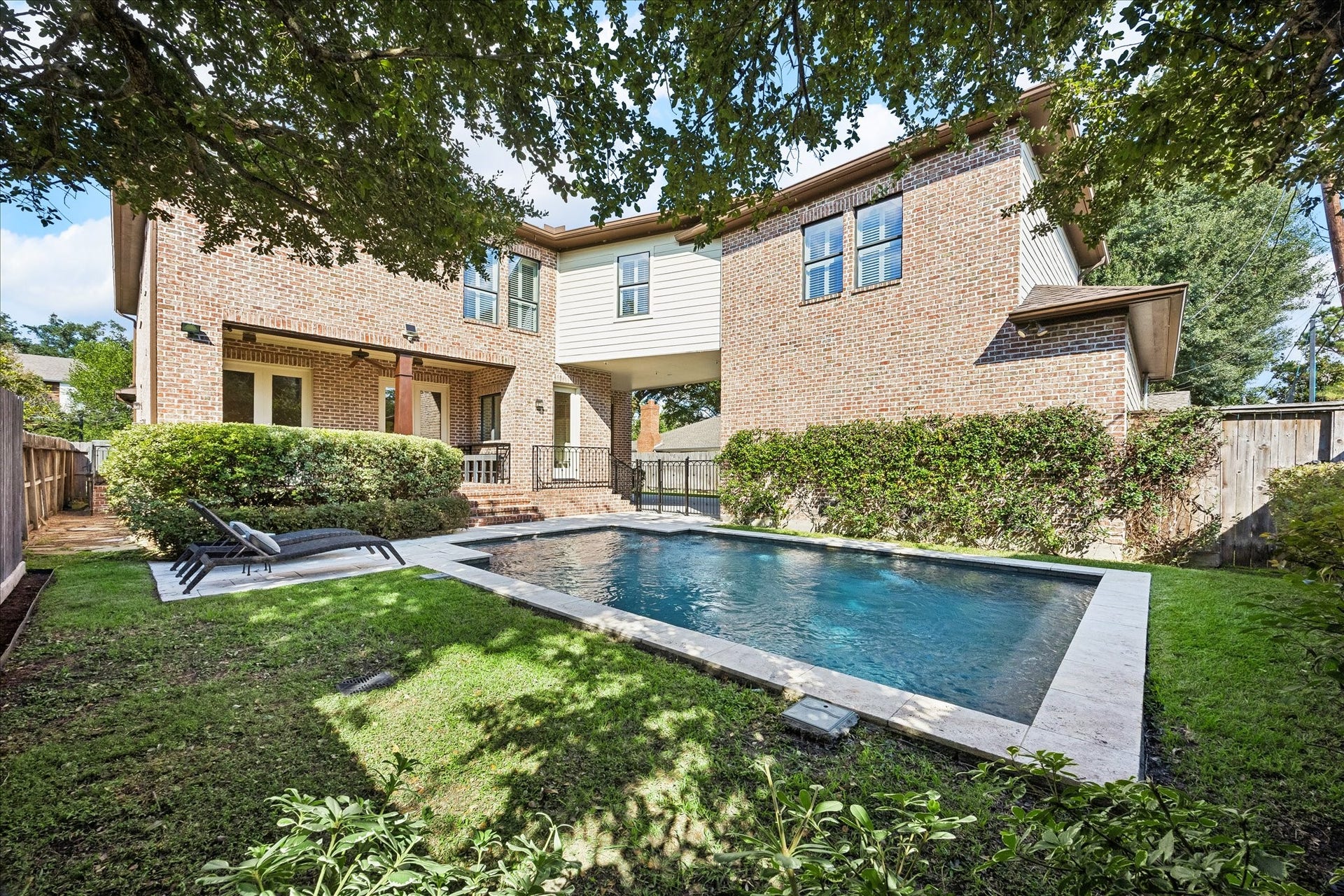 4037 Dumbarton Street, Houston, TX 77025 This charming brick home with a serene backyard features a sparkling pool, lush greenery, and a cozy patio area perfect for relaxation and entertaining.