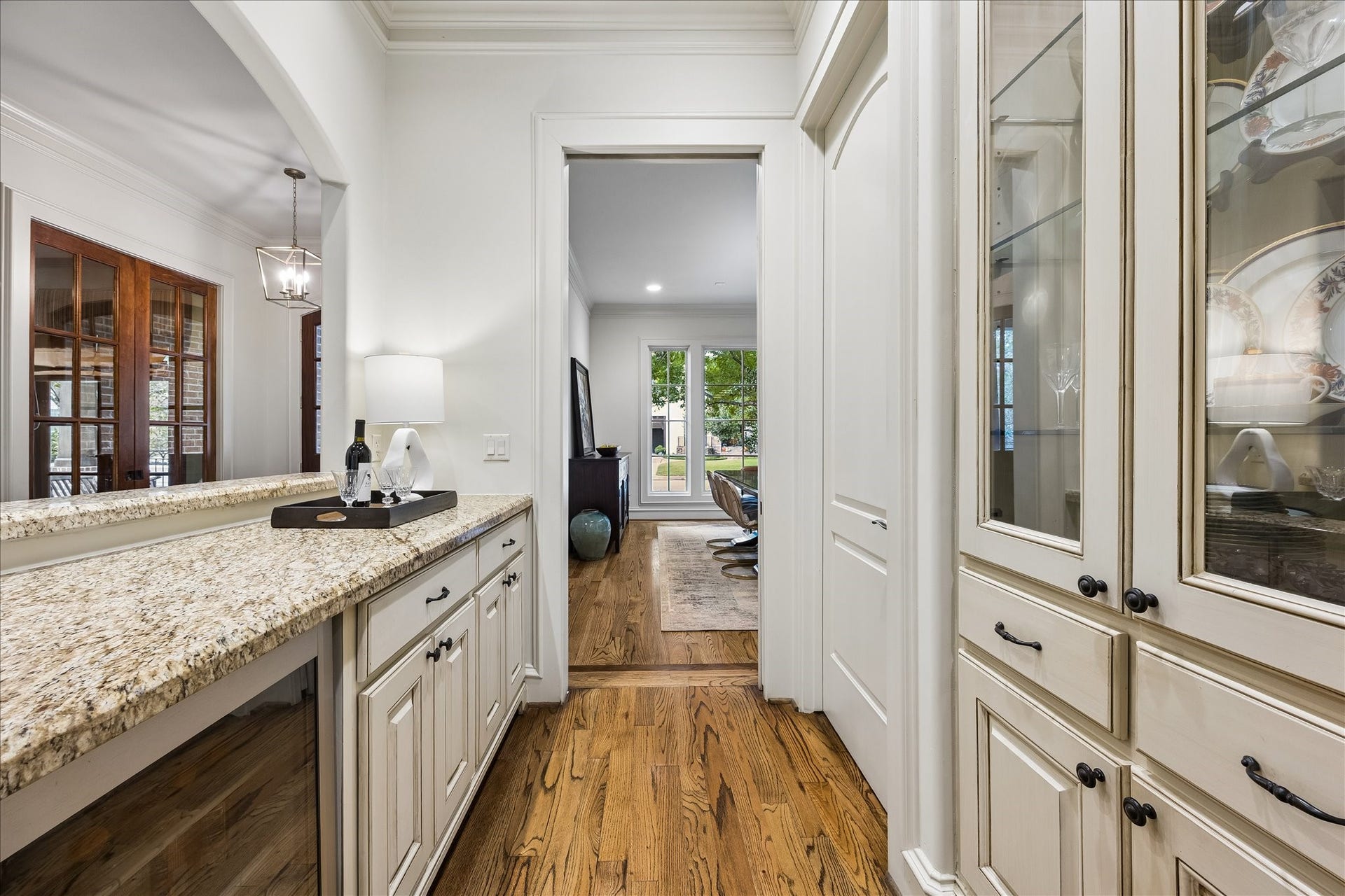 4037 Dumbarton Street, Houston, TX 77025 The buffet area sits between the formal dining room and large kitchen, all with rich wood floors, a serving counter, and glass-front cabinetry to showcase your special china and crystal.