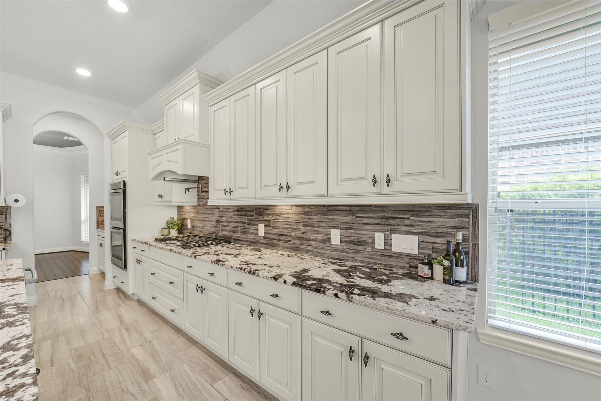 21011 Atascocita Point Drive, Humble, TX 77346 Under cabinet lighting, this photo leads through the butler's pantry, large walk-in pantry and into the formal dining room