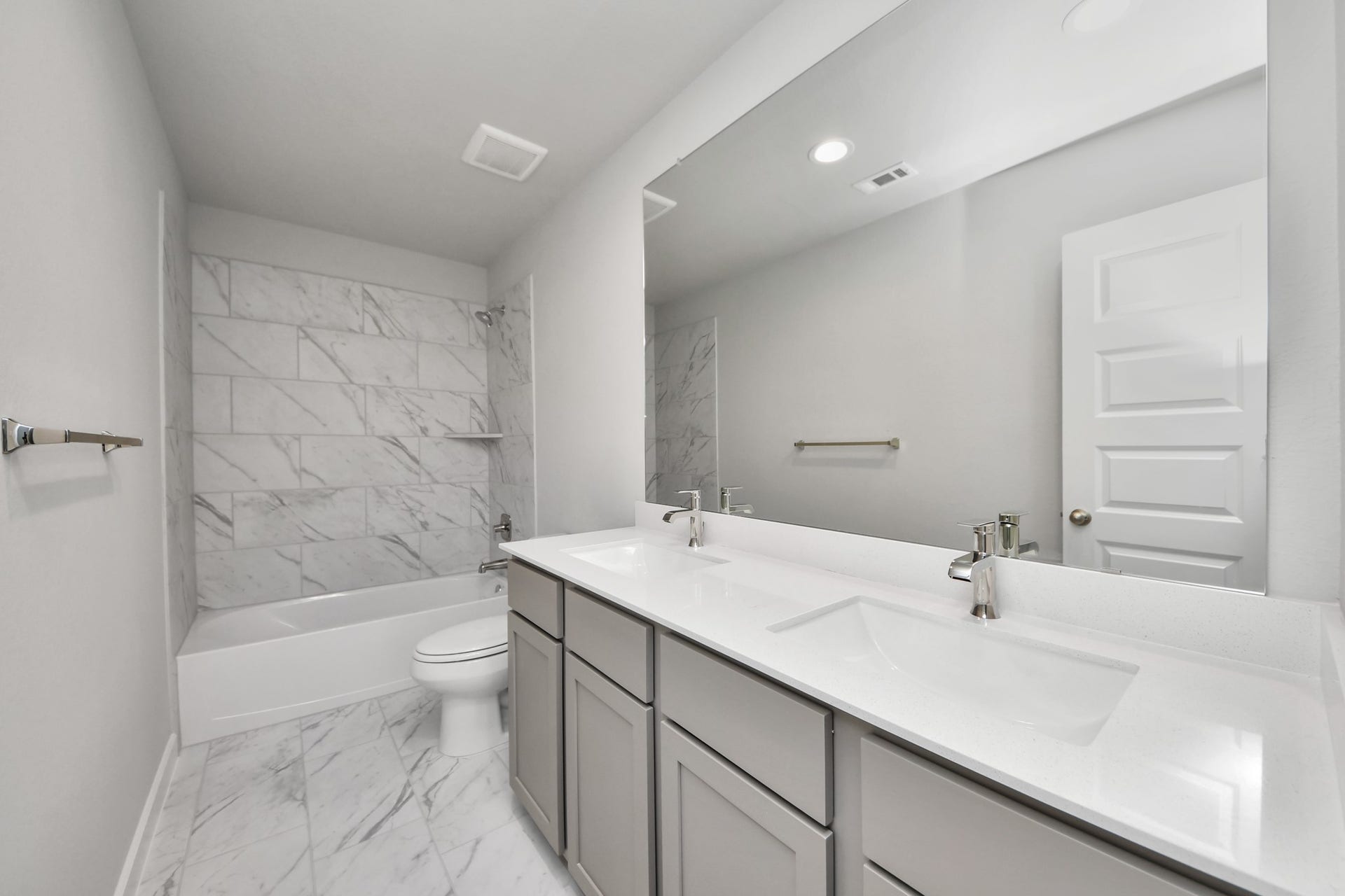 15315 Geranium Field Drive, Houston, TX 77044 Secondary bath features tile flooring, bath/shower combo with tile surround, light stained wood cabinets, beautiful light countertop. Sample photo of completed home with similar floor plan. Actual colors and selections may vary.