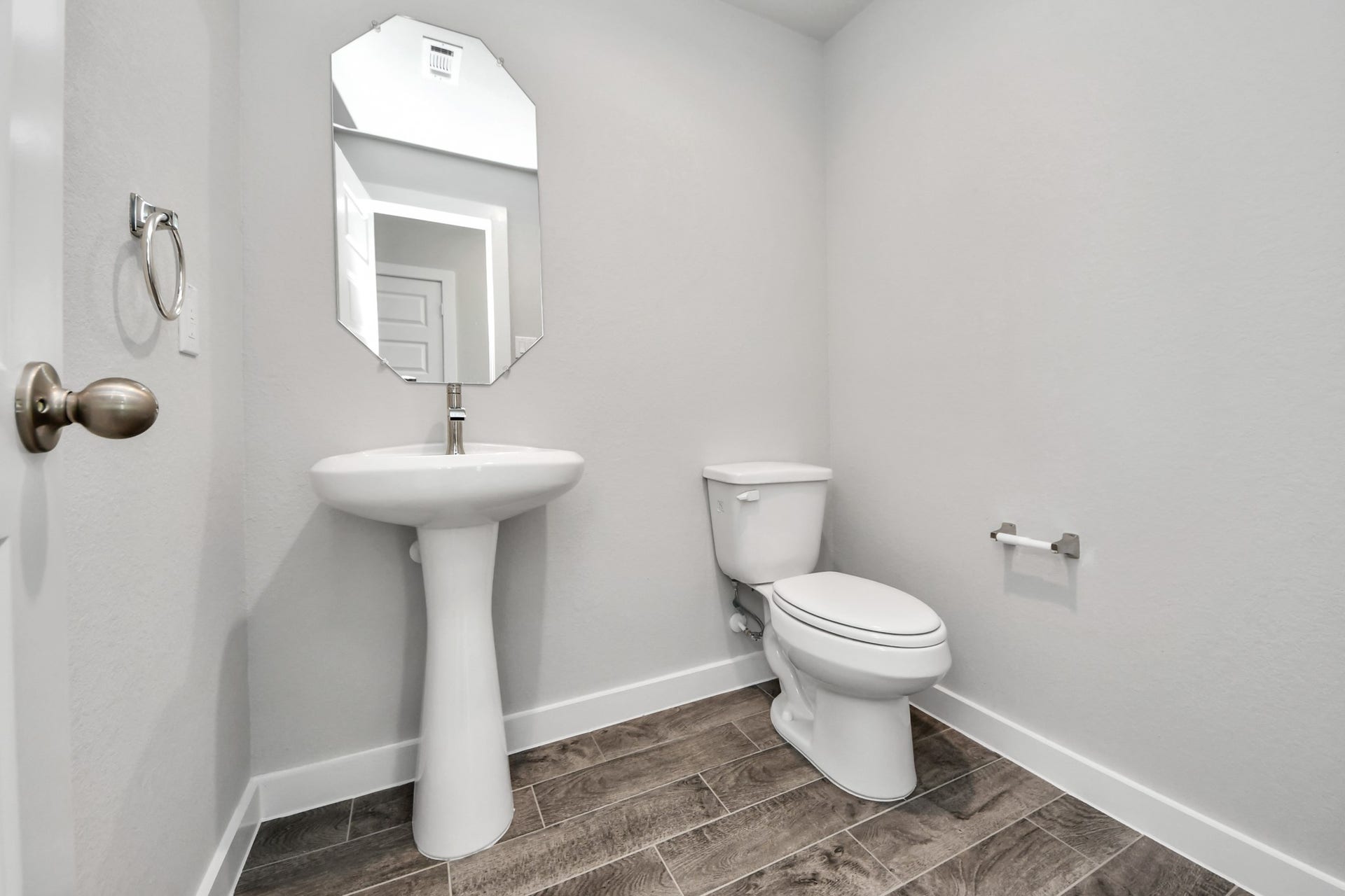 15315 Geranium Field Drive, Houston, TX 77044 This half bathroom features a stylish pedestal sink, modern hardware, and bright recessed lighting, creating a sleek and inviting space. Sample photo of completed home with similar floor plan. Actual colors and selections may vary.