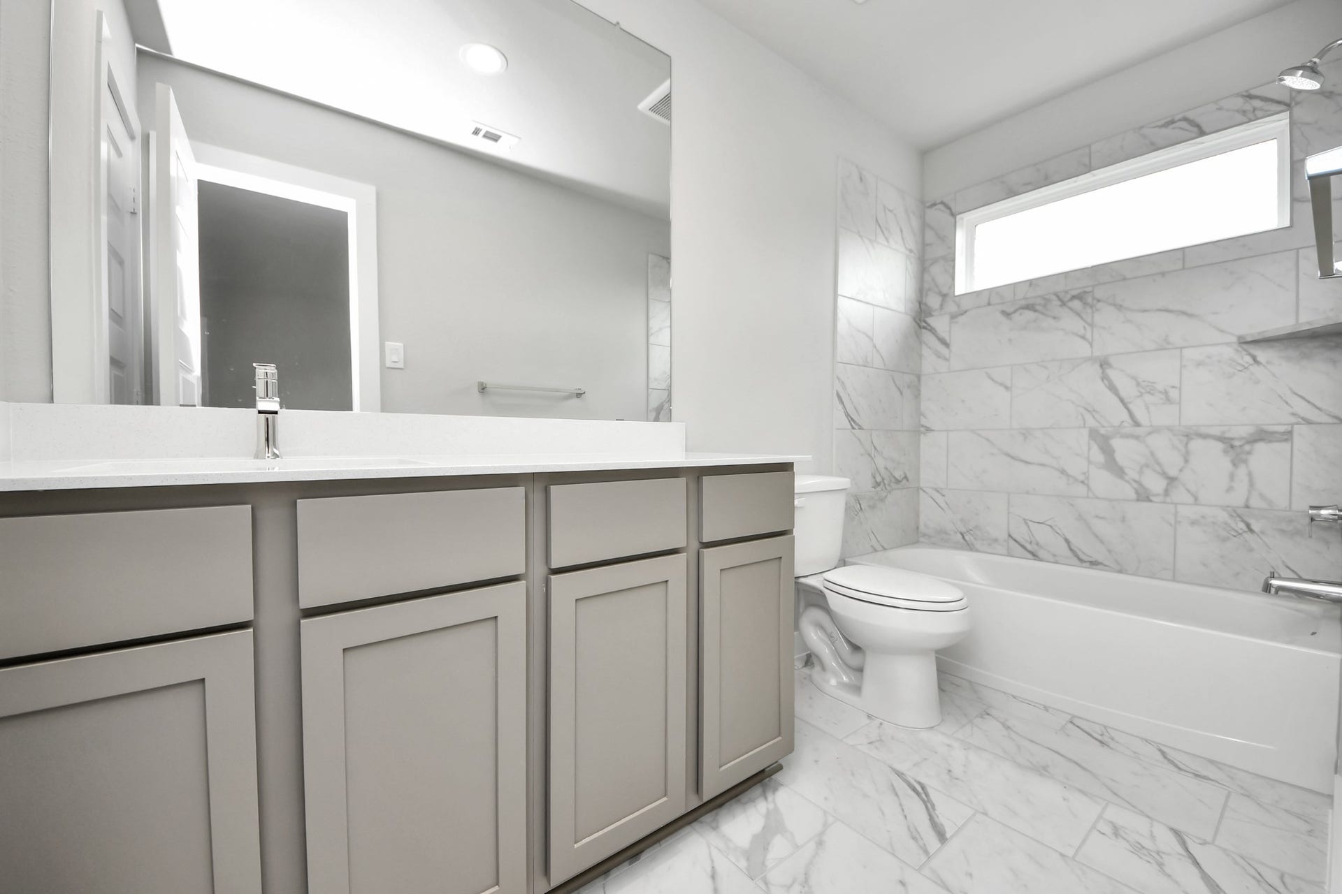 15315 Geranium Field Drive, Houston, TX 77044 Secondary bath features tile flooring, bath/shower combo with tile surround, light stained wood cabinets, beautiful light countertop. Sample photo of completed home with similar floor plan. Actual colors and selections may vary.