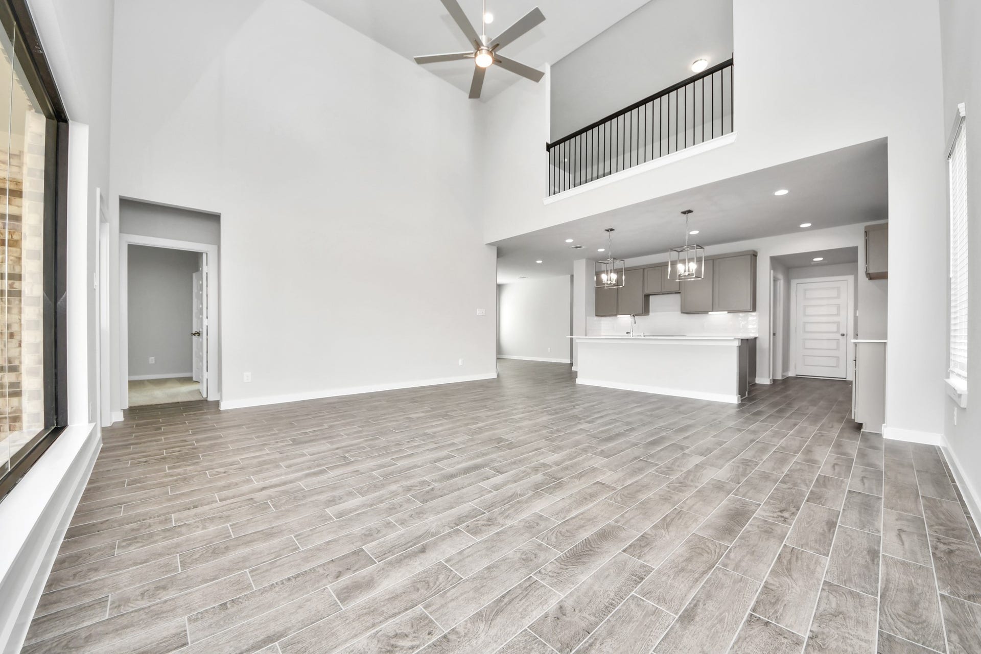 15315 Geranium Field Drive, Houston, TX 77044 Relax and unwind in this inviting family room, illuminated by abundant natural light streaming in through tall windows, complemented by high ceilings and stunning flooring. Stay comfortable year-round with the gentle breeze from the ceiling fan, creating the perfect atmosphere for family gatherings. Sample photo of completed home with similar floor plan. Actual colors and selections may vary.