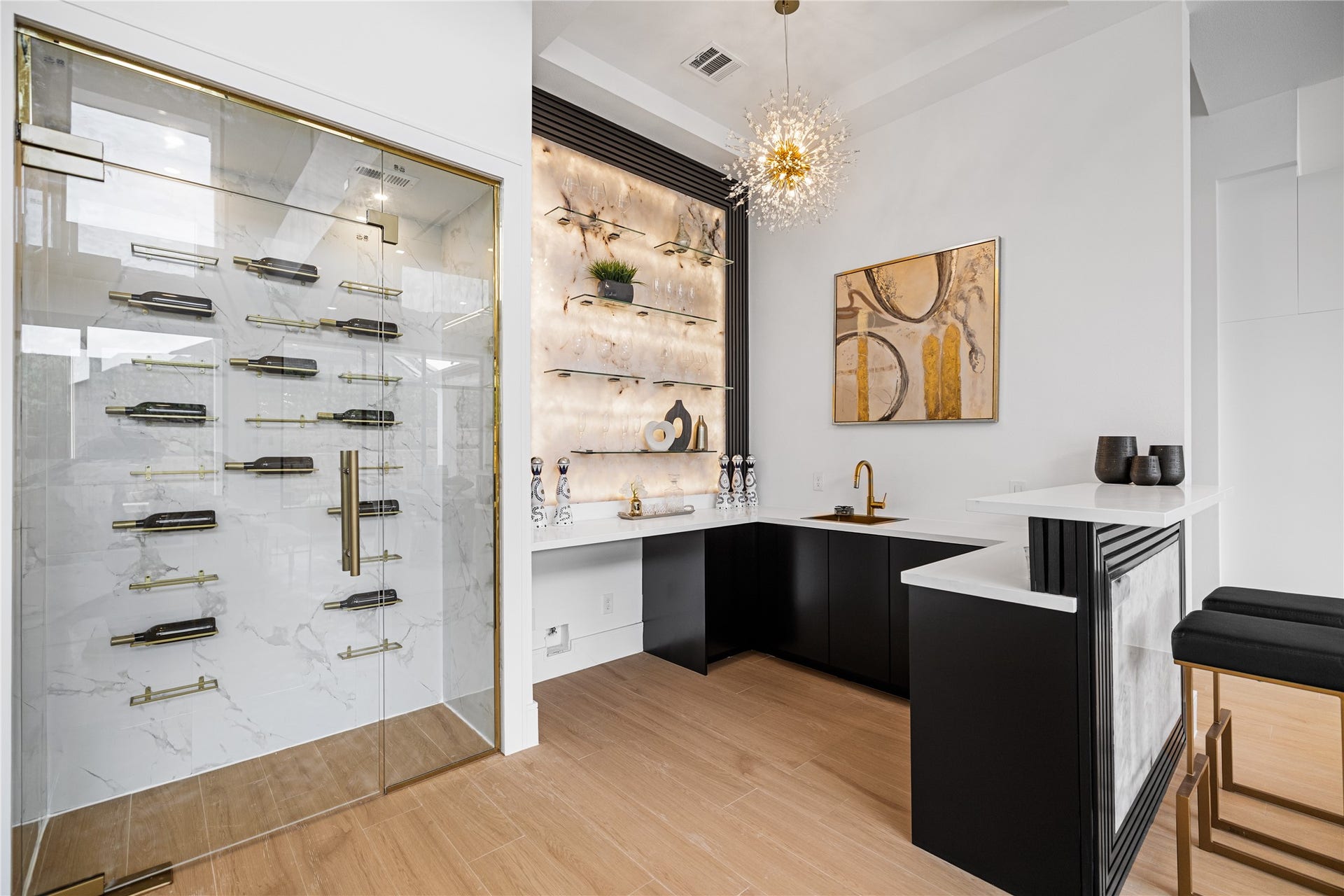 A sophisticated wine storage and bar area designed to elevate every occasion, complete with an ambient, backlit display wall showcasing your finest top-shelf spirits. This space is thoughtfully appointed with a dedicated sink, adding convenience and functionality for effortless entertaining.