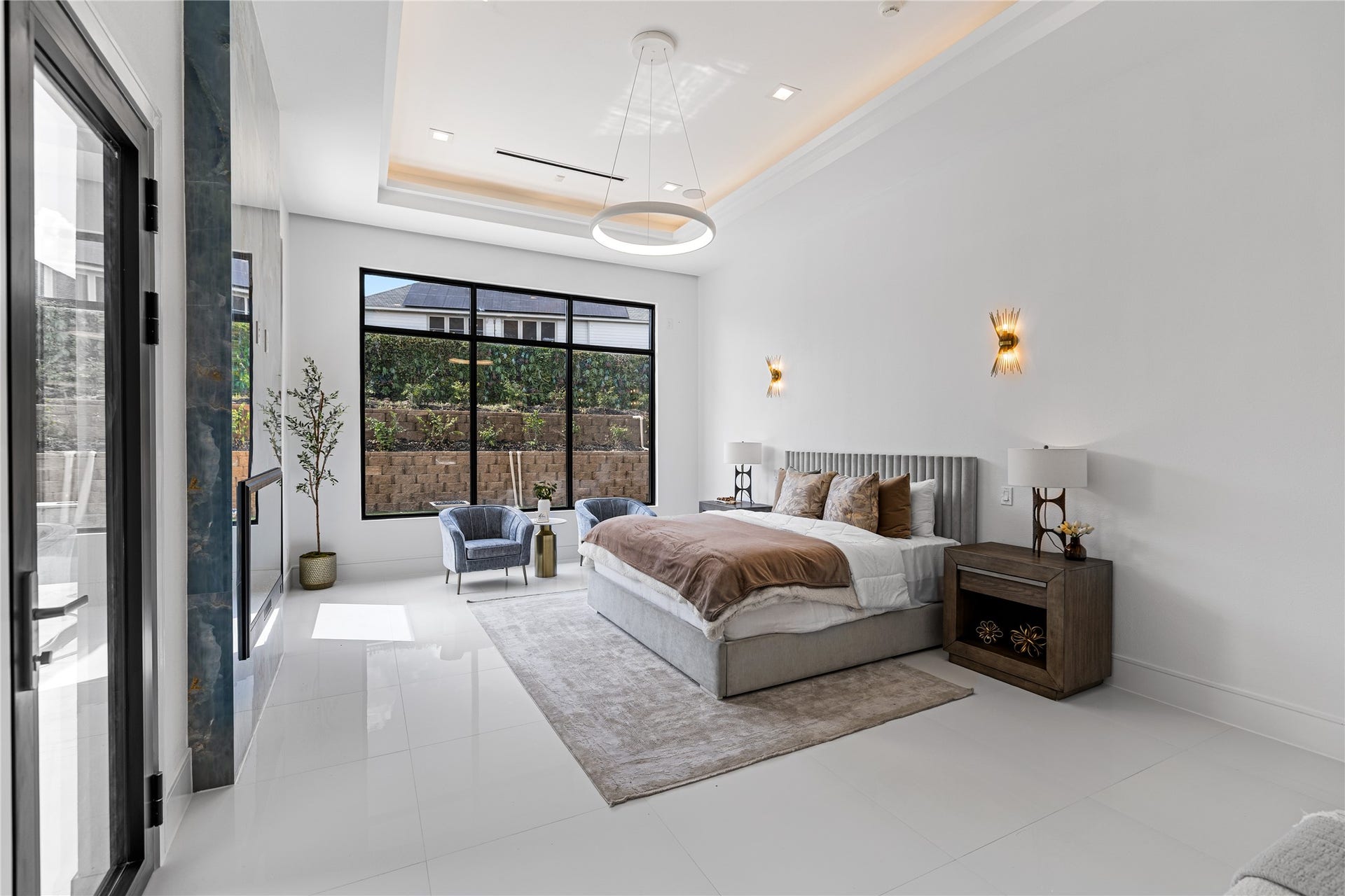This primary suite is elevated by bespoke built-in wall sconces. A private exterior door provides direct access to the backyard oasis, creating and effortless connection between the refined interior and outdoor living spaces.