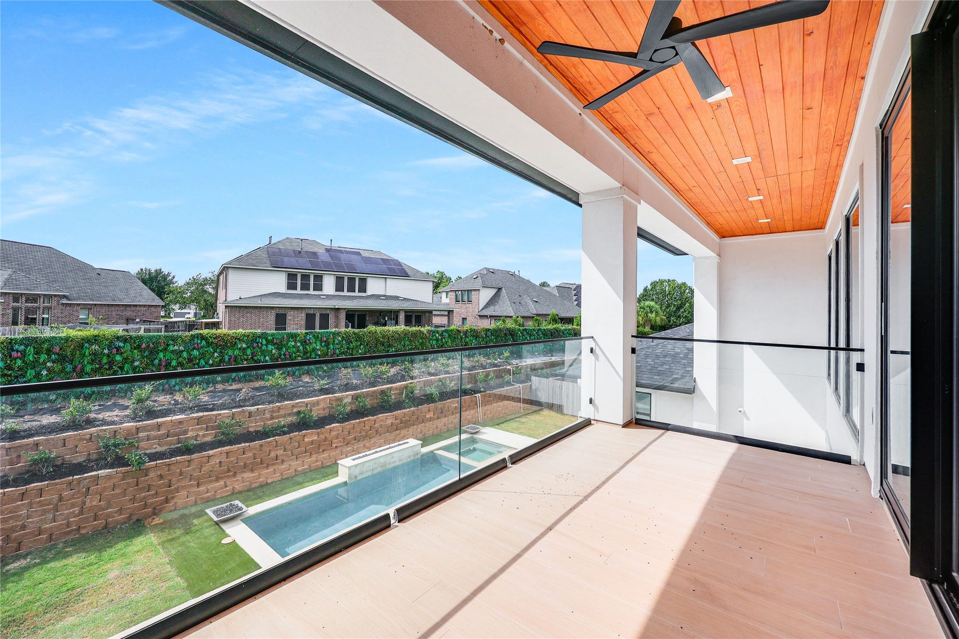 Step onto the covered terrace, complete with a ceiling fan, teak ceiling accents, and serene views of your private escape from the city beyond.