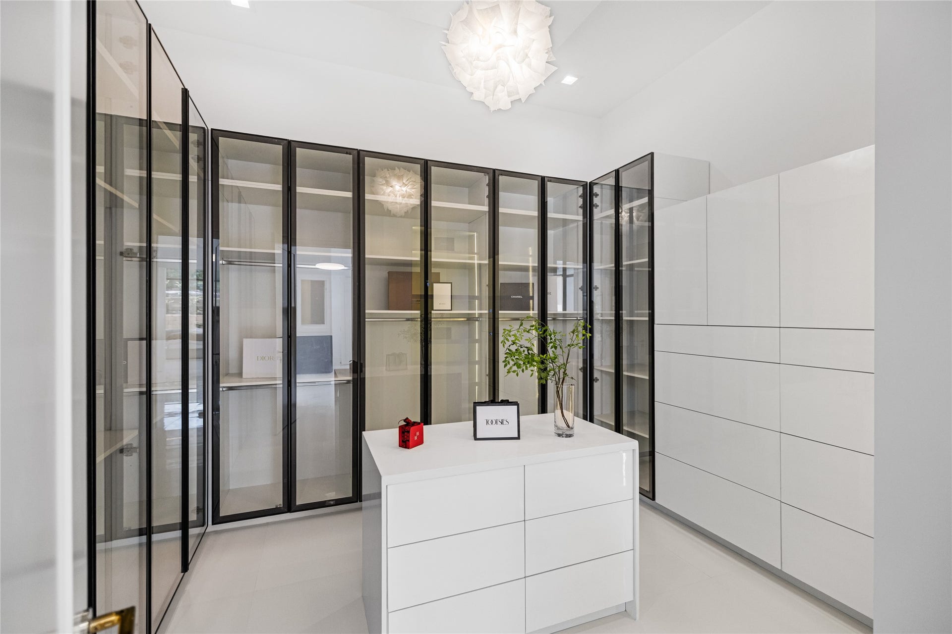 One of two generously appointed custom closets offering abundant hanging space, thoughtfully integrated built-in storage, and refined ambient lighting.