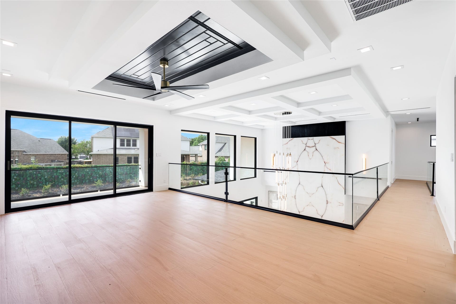 At the top of the stairs (to the very right of this picture), turn to the right and the hallway leads to a private en-suite bedroom. Turn left at the top of the stairs and discover an impressive game room, framed by expansive sliding glass doors that open seamlessly onto a beautiful outdoor terrace overlooking the backyard oasis below.