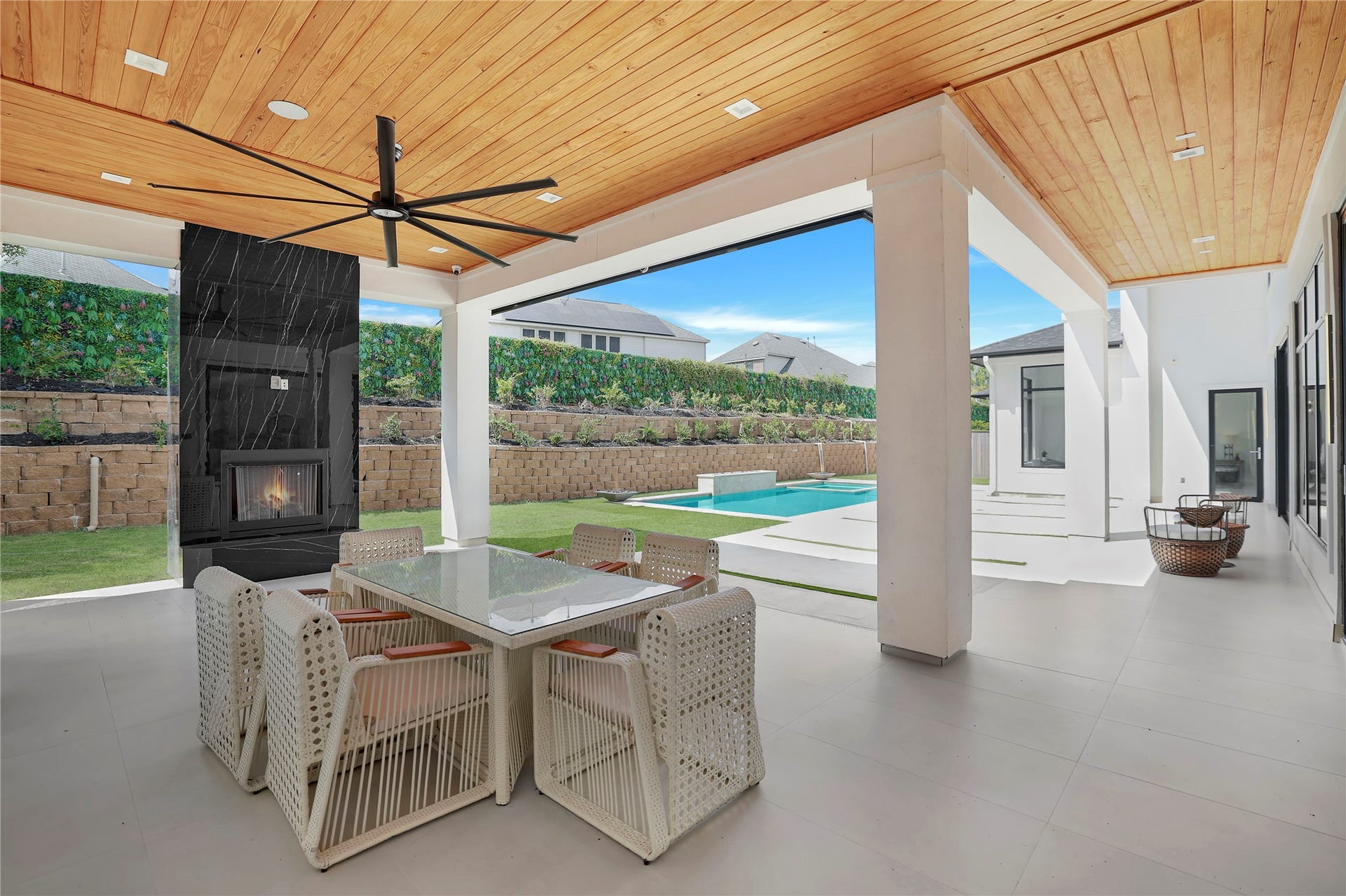 Welcome outside to the backyard where an expansive covered outdoor living area is anchored by a dramatic marble-clad fireplace. It's an exceptional setting for effortless entertaining.