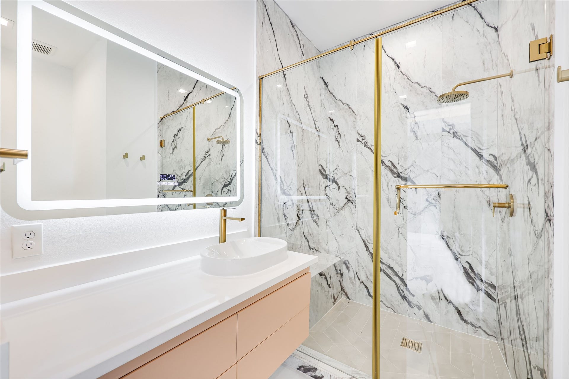 The private en-suite bath features a marble walk-in shower in this secondary bedroom.