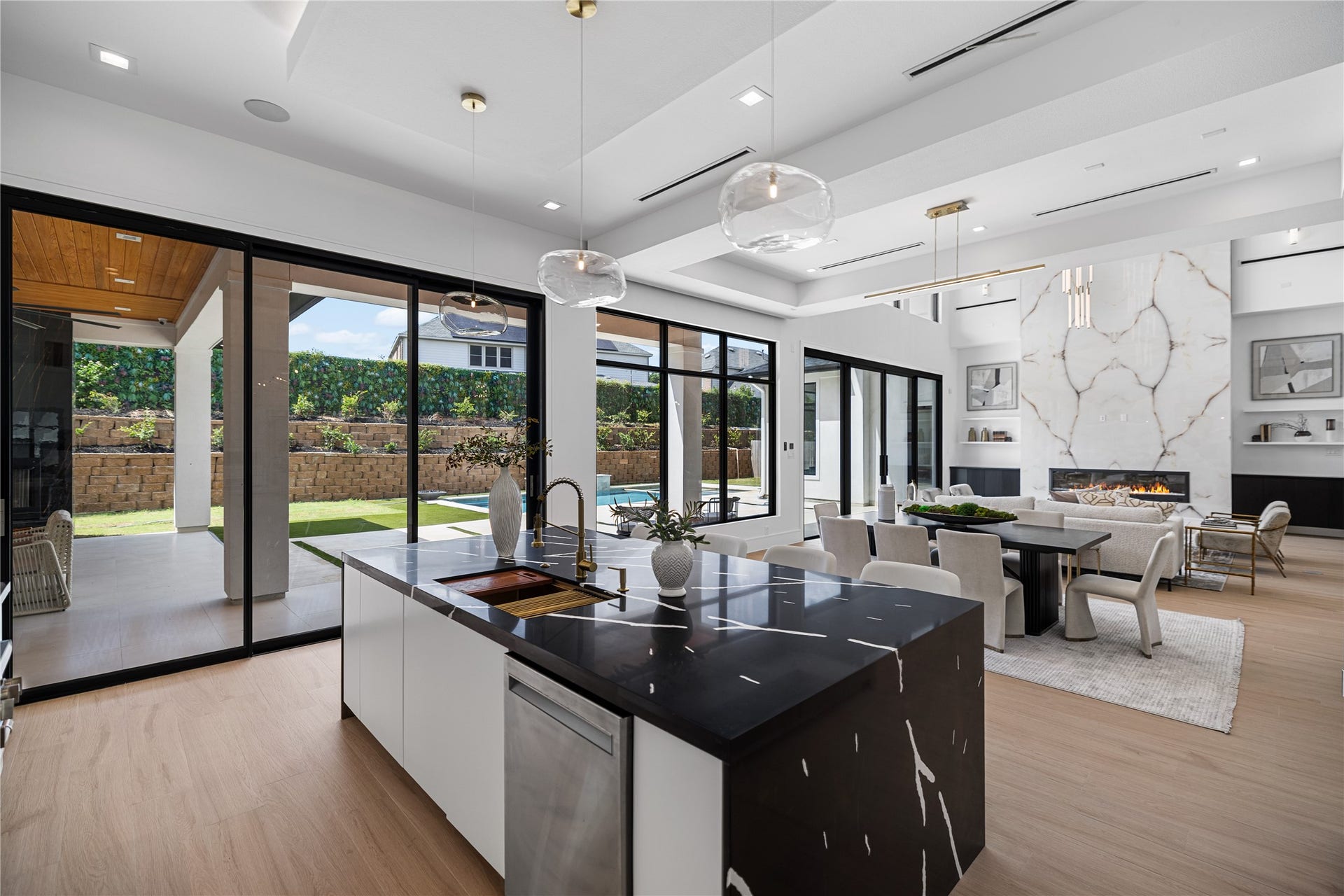This expansive island kitchen offers unobstructed views across the backyard oasis, with seamless sightline to the covered patio, summer kitchen, and pool and spa.