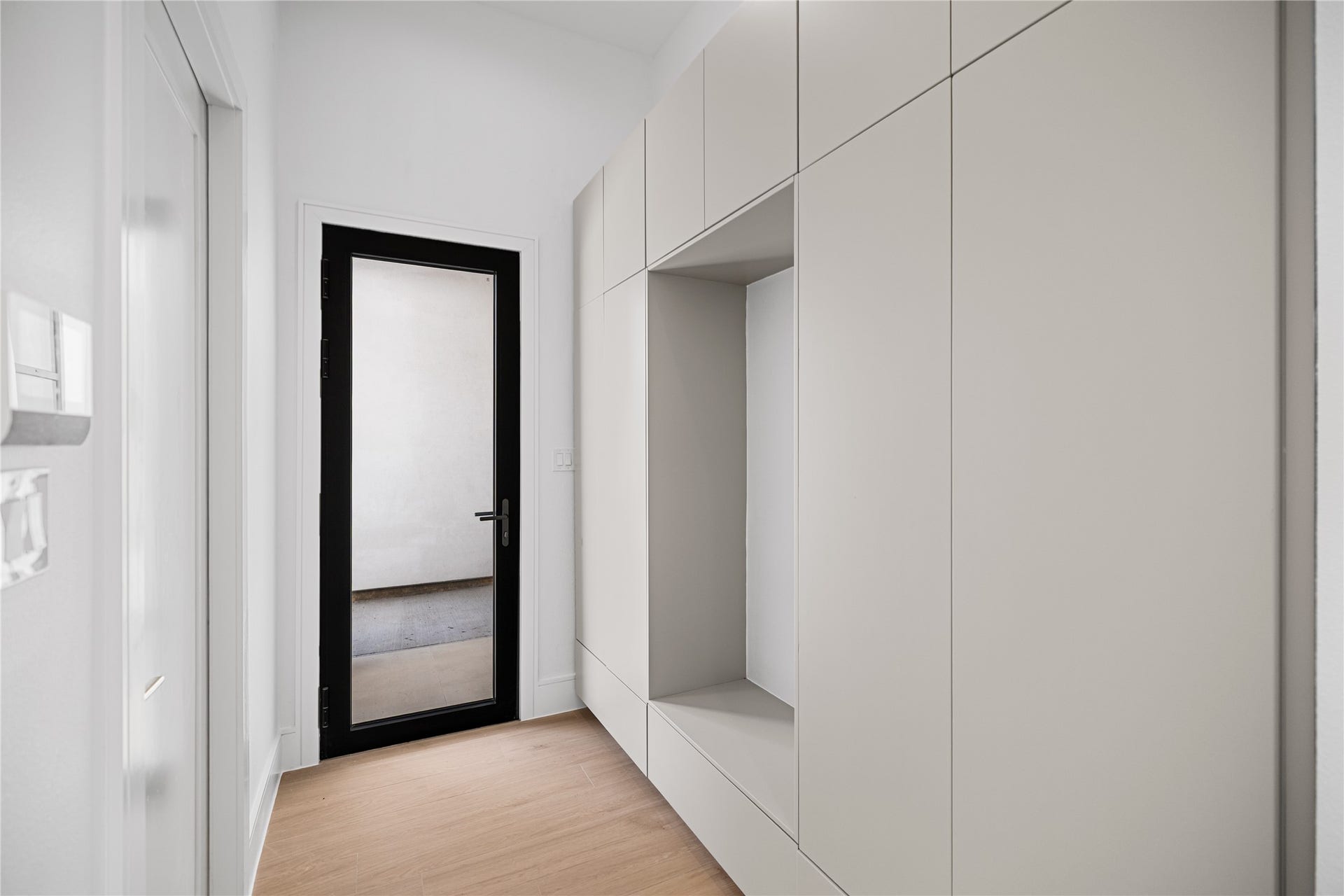 A spacious first-floor mudroom with abundant built-in storage, offering direct access to the two car garage (another 1 car garage has a separate entrance). Steel framed door ahead leads to the outdoor driveway.