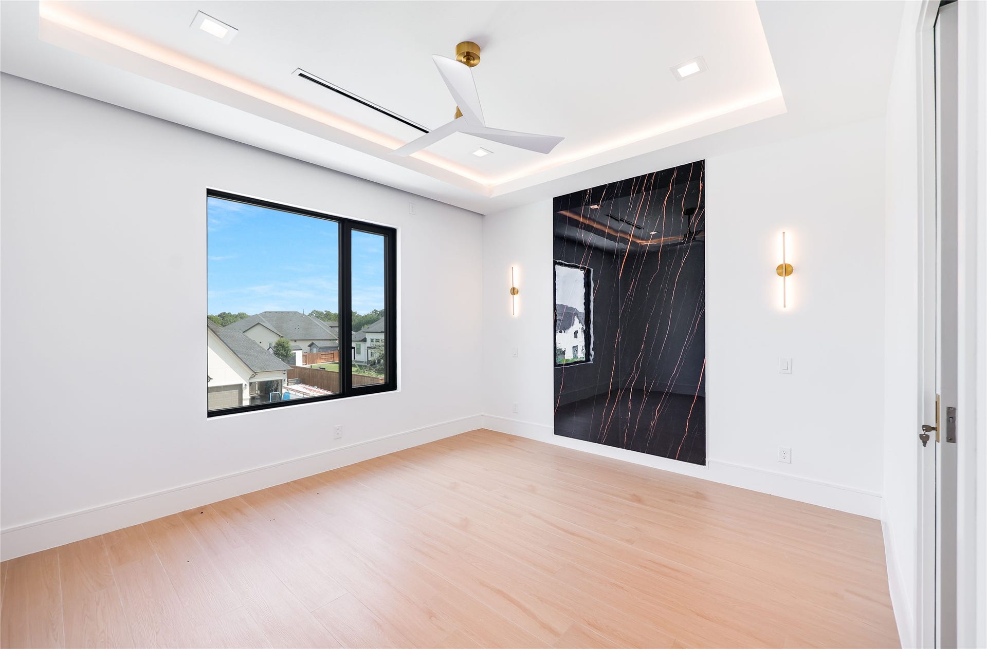 The third of three upstairs bedrooms, continuing the home's luxurious design with custom marble accents, designer sconces, refined lighting, and beautifully detailed tray ceilings.