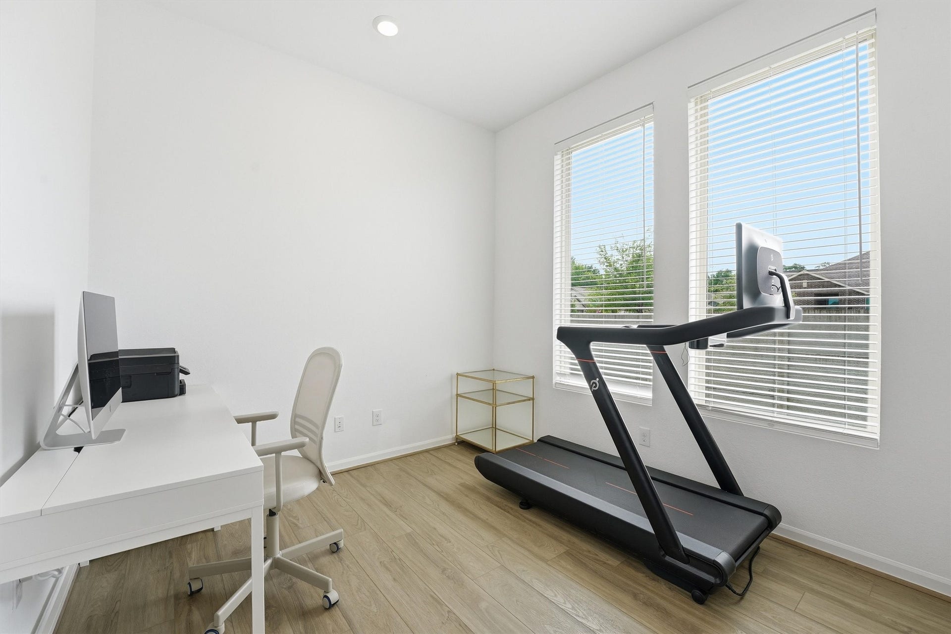 Bright, versatile home office featuring ample natural light from large windows.