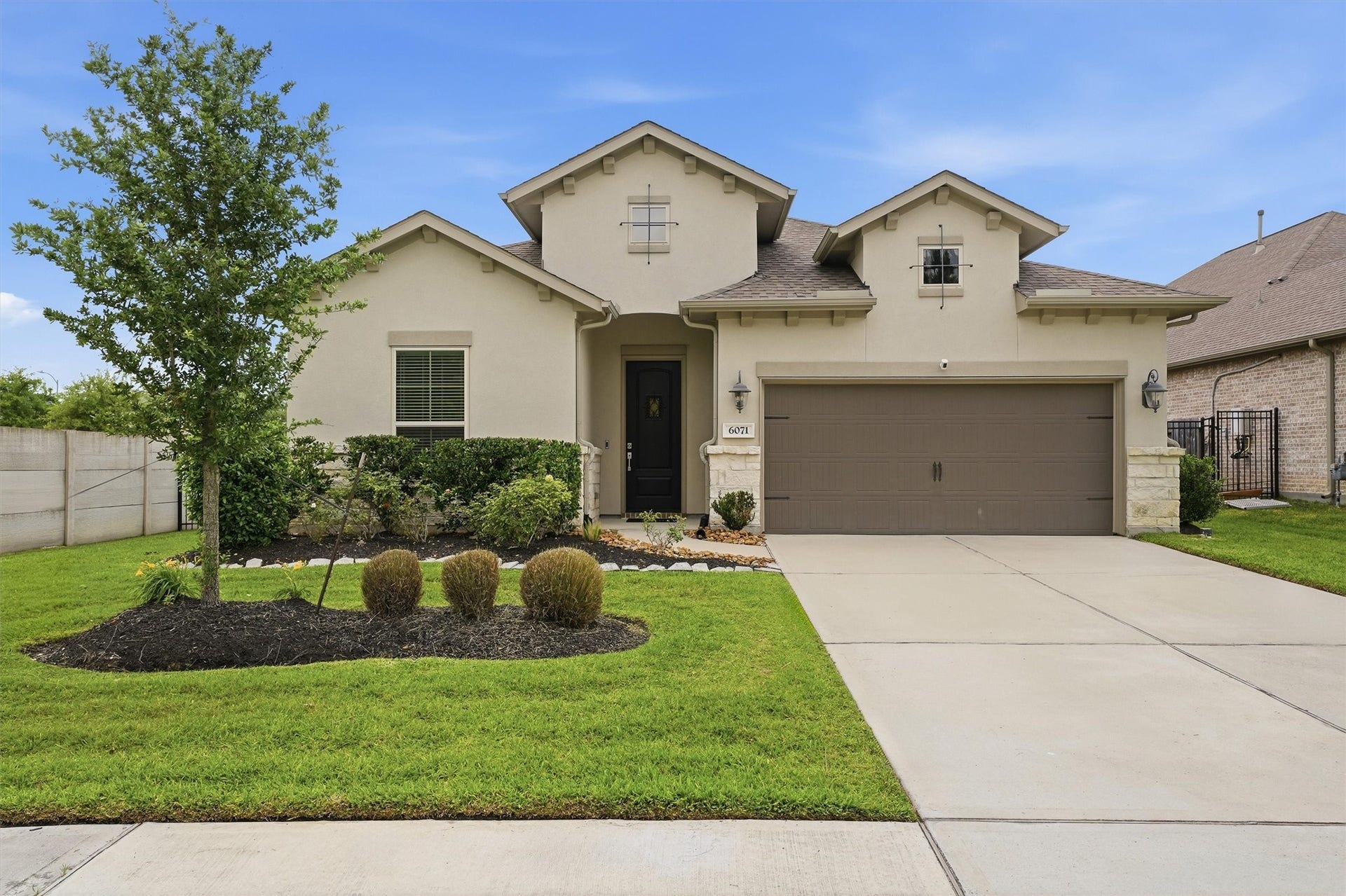 Charming single-story home with a modern facade, a well-maintained lawn, and a spacious two-car garage.