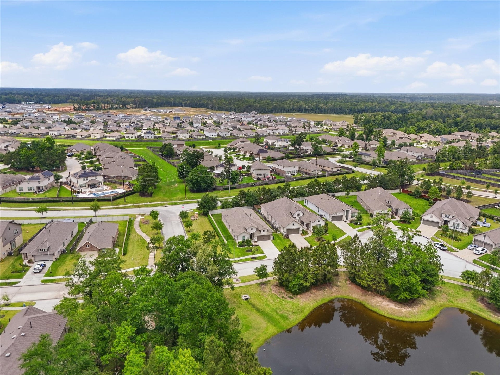 Charming suburban neighborhood with well-maintained homes, tree-lined streets, and a peaceful pond, offering a serene and inviting community atmosphere.