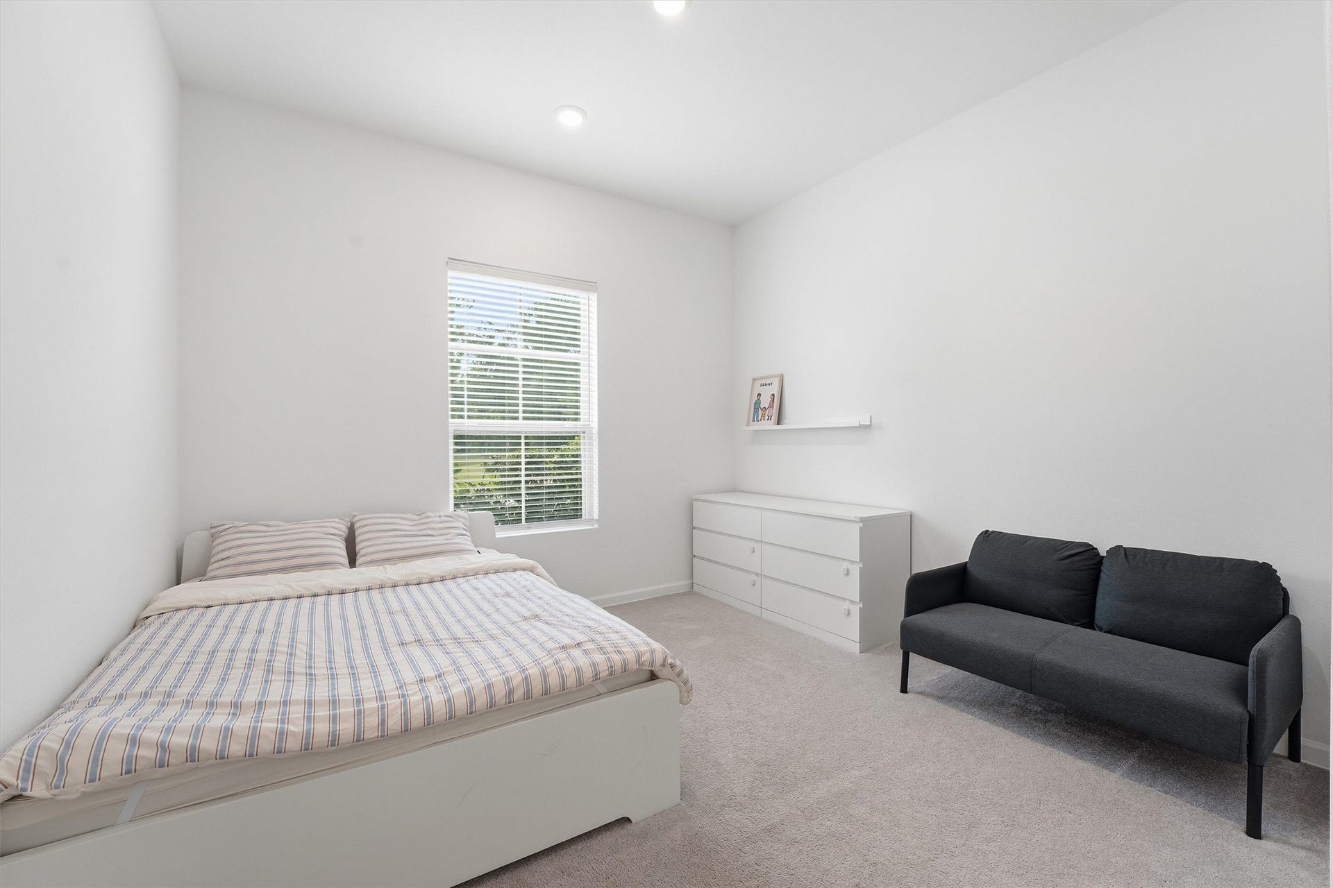 Bright and spacious bedroom with added natural light from a large window.