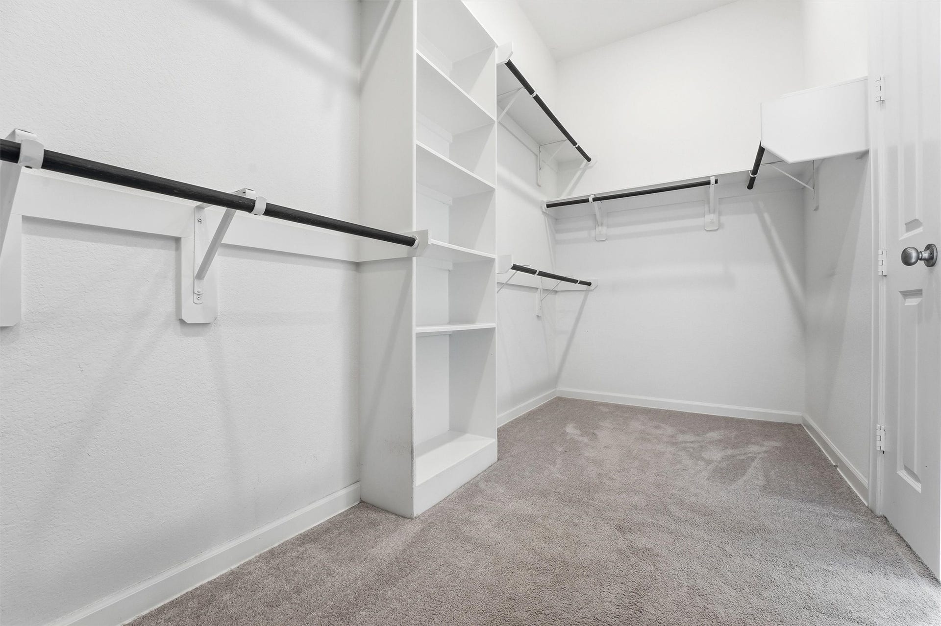 Spacious walk-in closet with ample shelving and hanging space, perfect for organizing your wardrobe.
