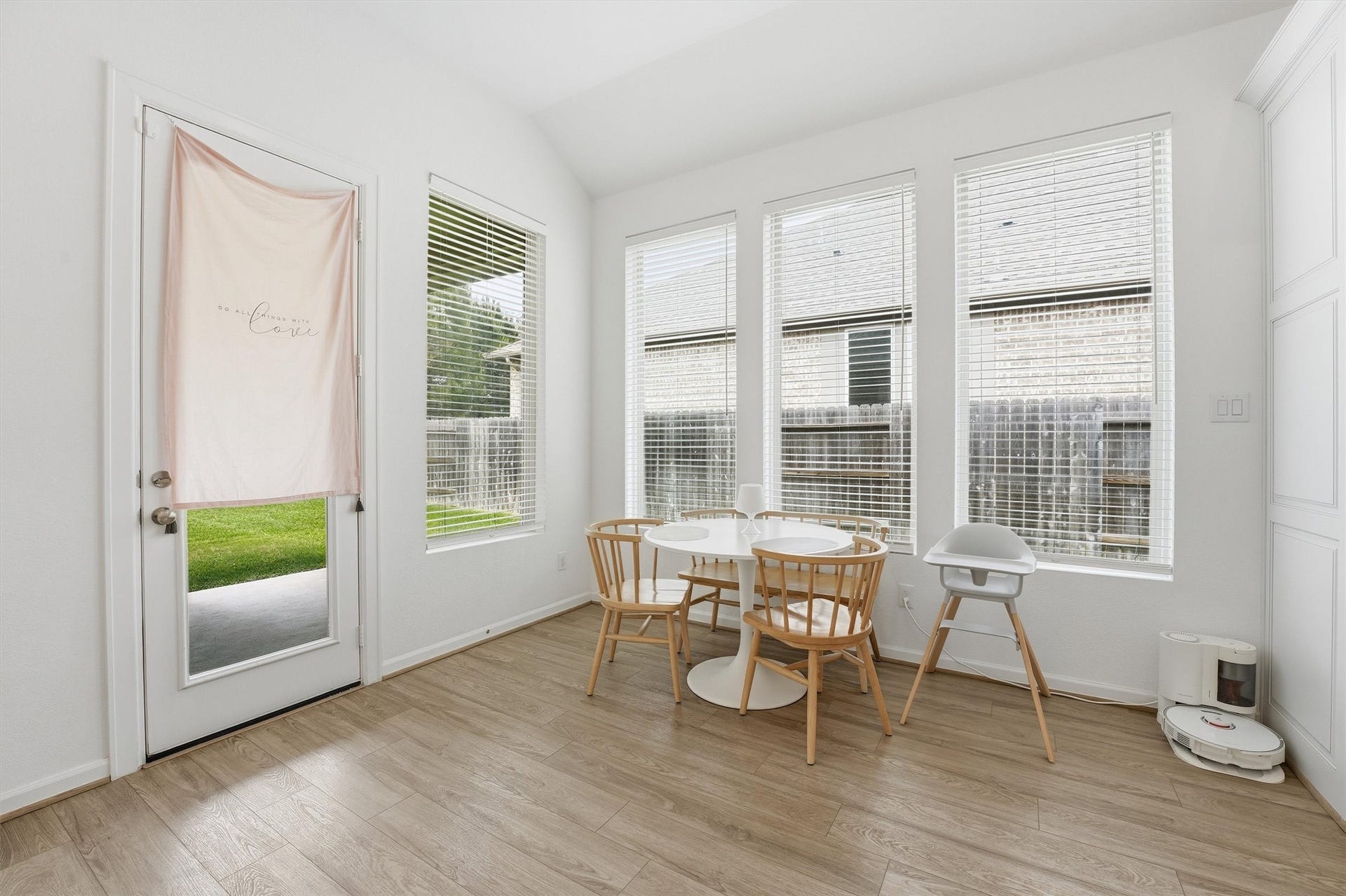 Bright and inviting dining area with large windows, modern flooring, and a cozy dining setup perfect for family meals.