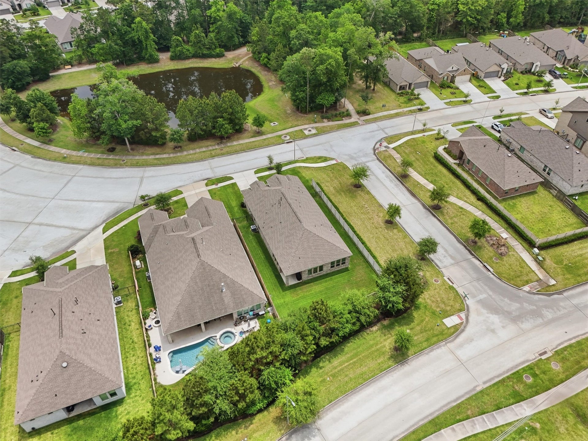 Charming neighborhood with spacious homes, lush greenery, and a serene pond nearby.