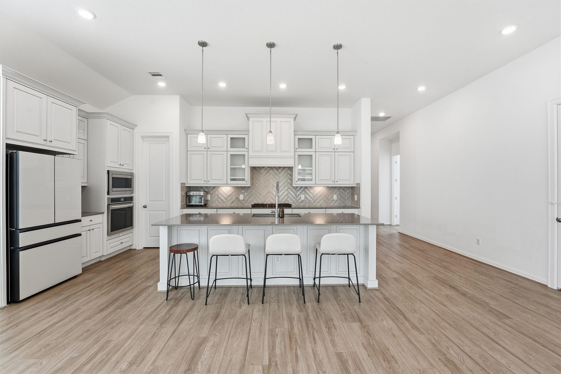 Modern kitchen with sleek cabinetry, a spacious island with seating, and stylish pendant lighting.
