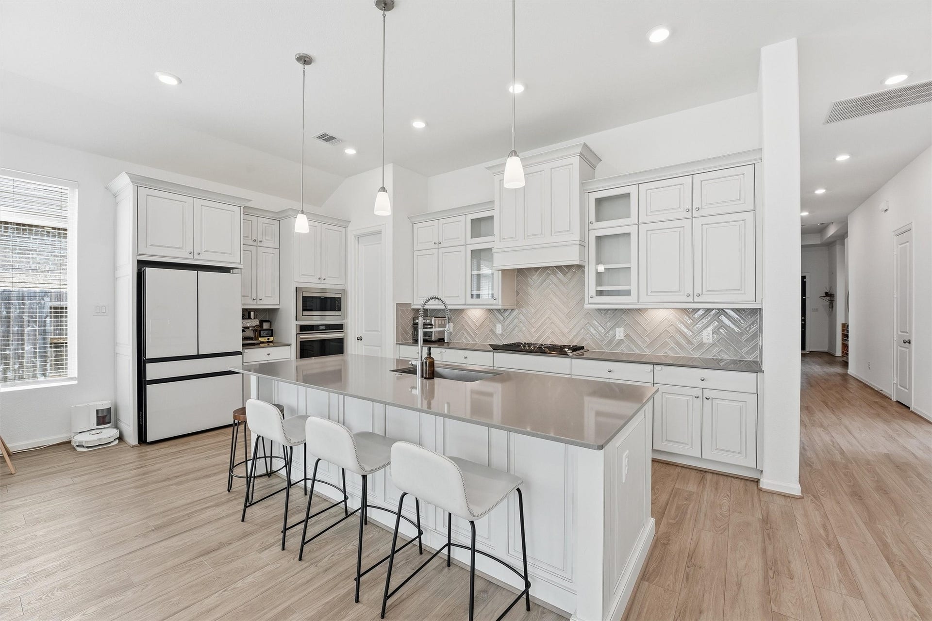 The Heart of the Home-A spacious island kitchen with white cabinetry, gas cooking, abundant storage and open sightlines to the living and dining areas.