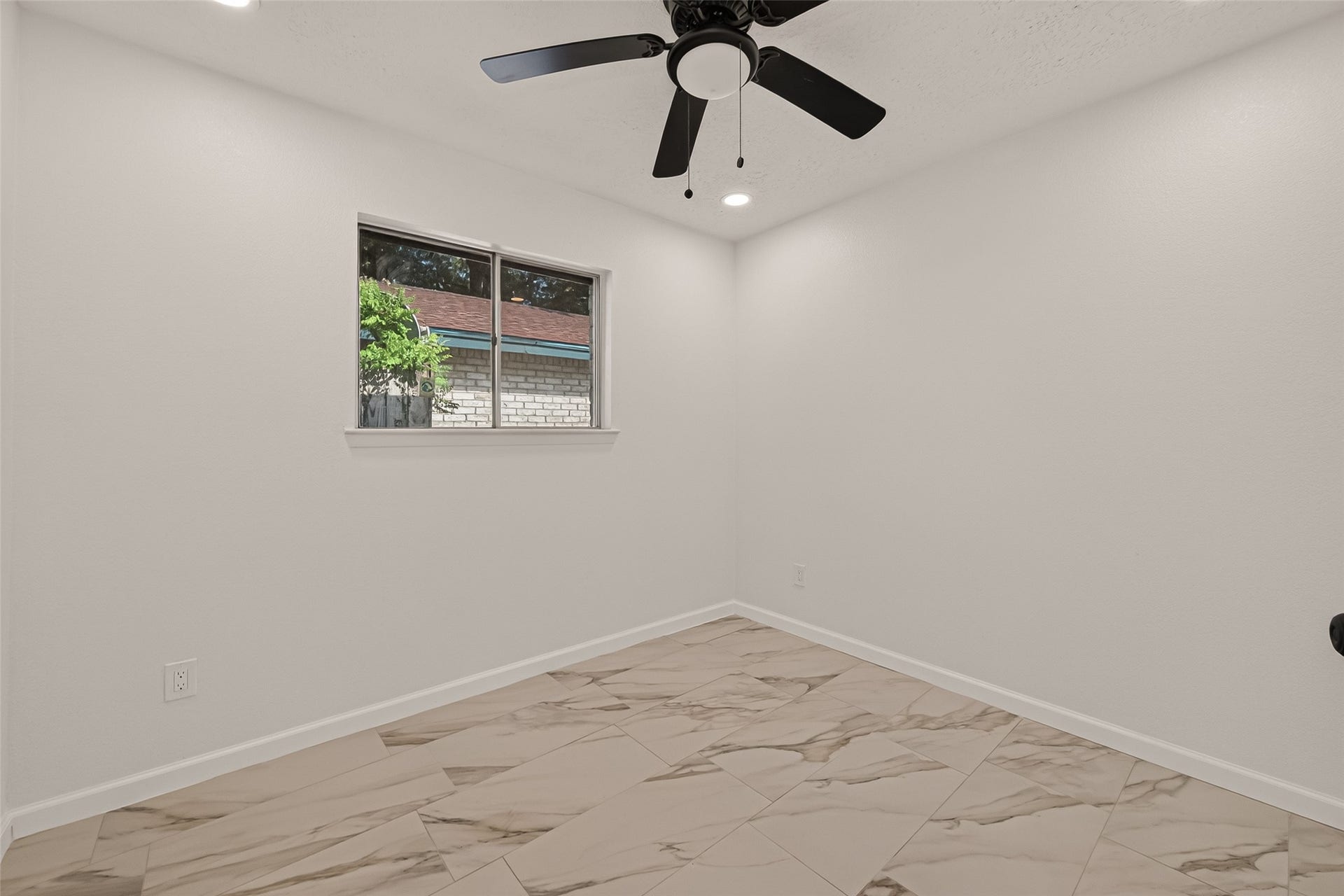 16619 Tibet Road, Friendswood, TX 77546 This room features a clean, modern design with light-colored walls and tile flooring. It includes a ceiling fan and a window providing natural light, creating a bright and airy atmosphere.