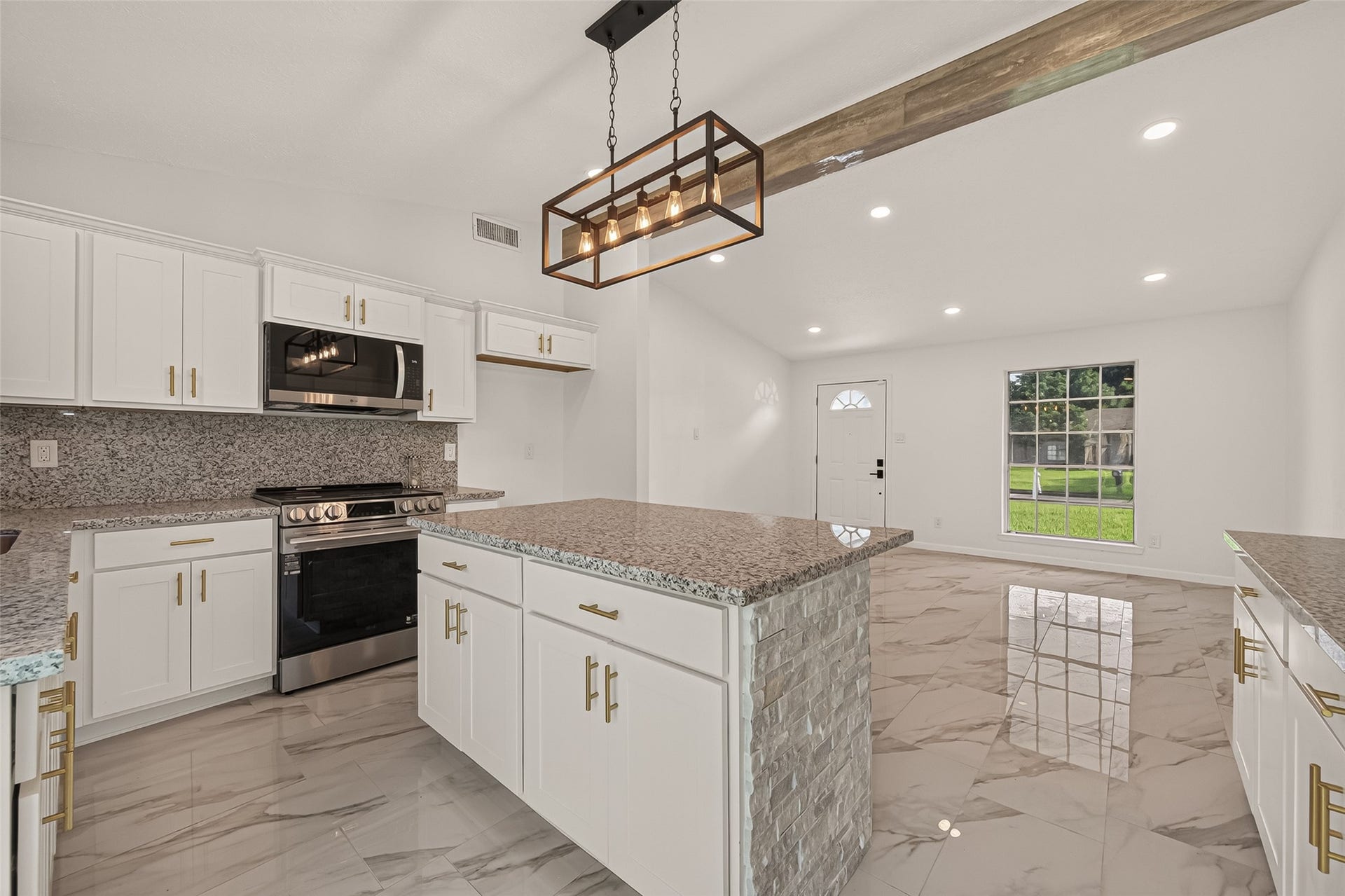 16619 Tibet Road, Friendswood, TX 77546 Bright, modern kitchen with granite countertops, stainless steel appliances, and sleek cabinetry. Features a large island, pendant lighting, and open floor plan with marble-style flooring.