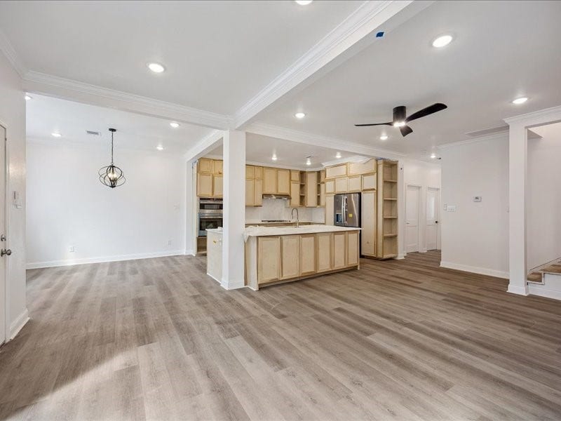 2123 Kingston Street, Houston, TX 77019 Kitchen & Living Area Expansive open layout with wide-plank flooring, recessed lighting, crown molding, and abundant natural light. Home is currently under renovation and not yet complete.