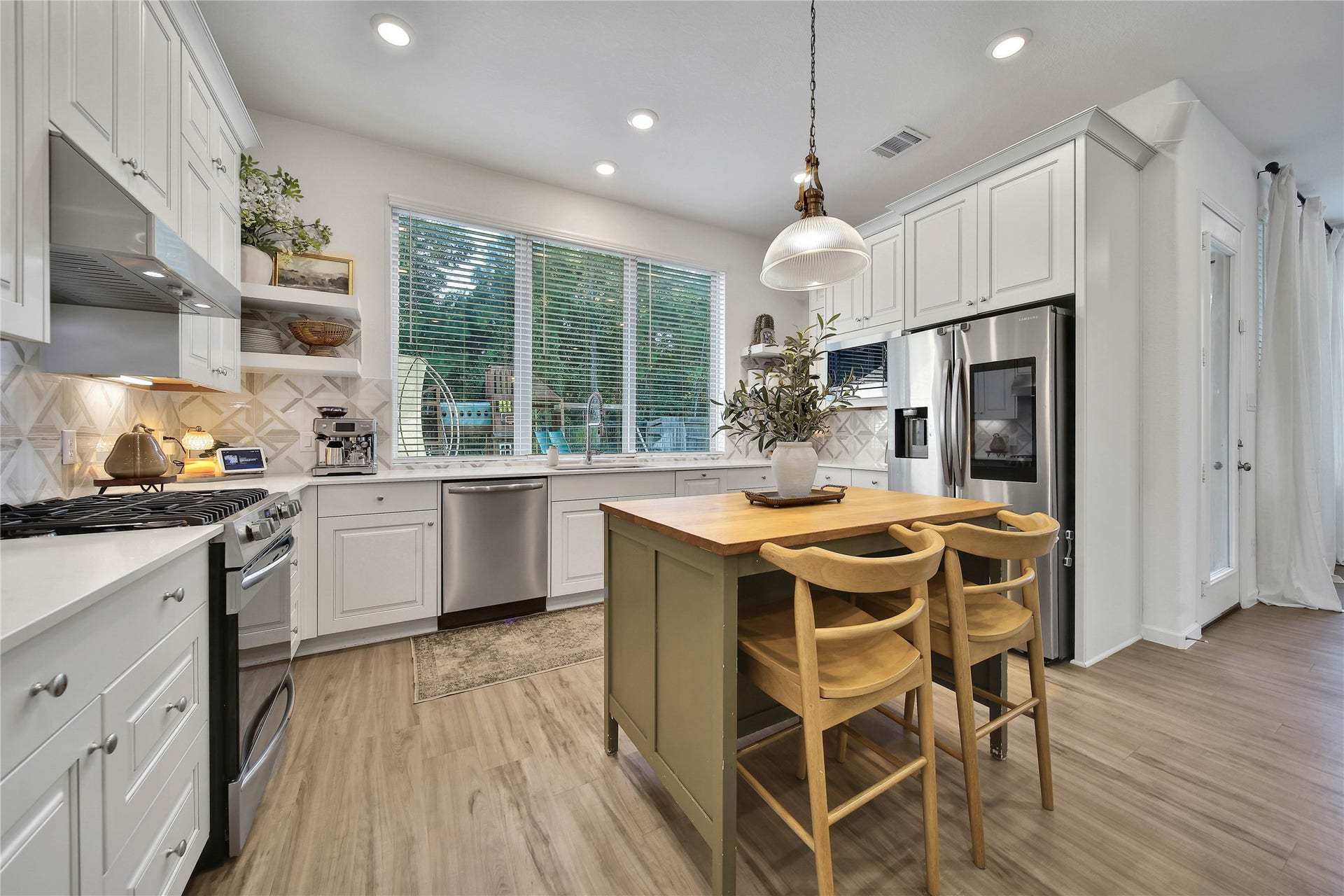 6048 Windward Falls Way, Porter, TX 77365 Portable island and 2 chairs stay with the home as it provides additional storage and seating. Upgraded light fixture over the island.