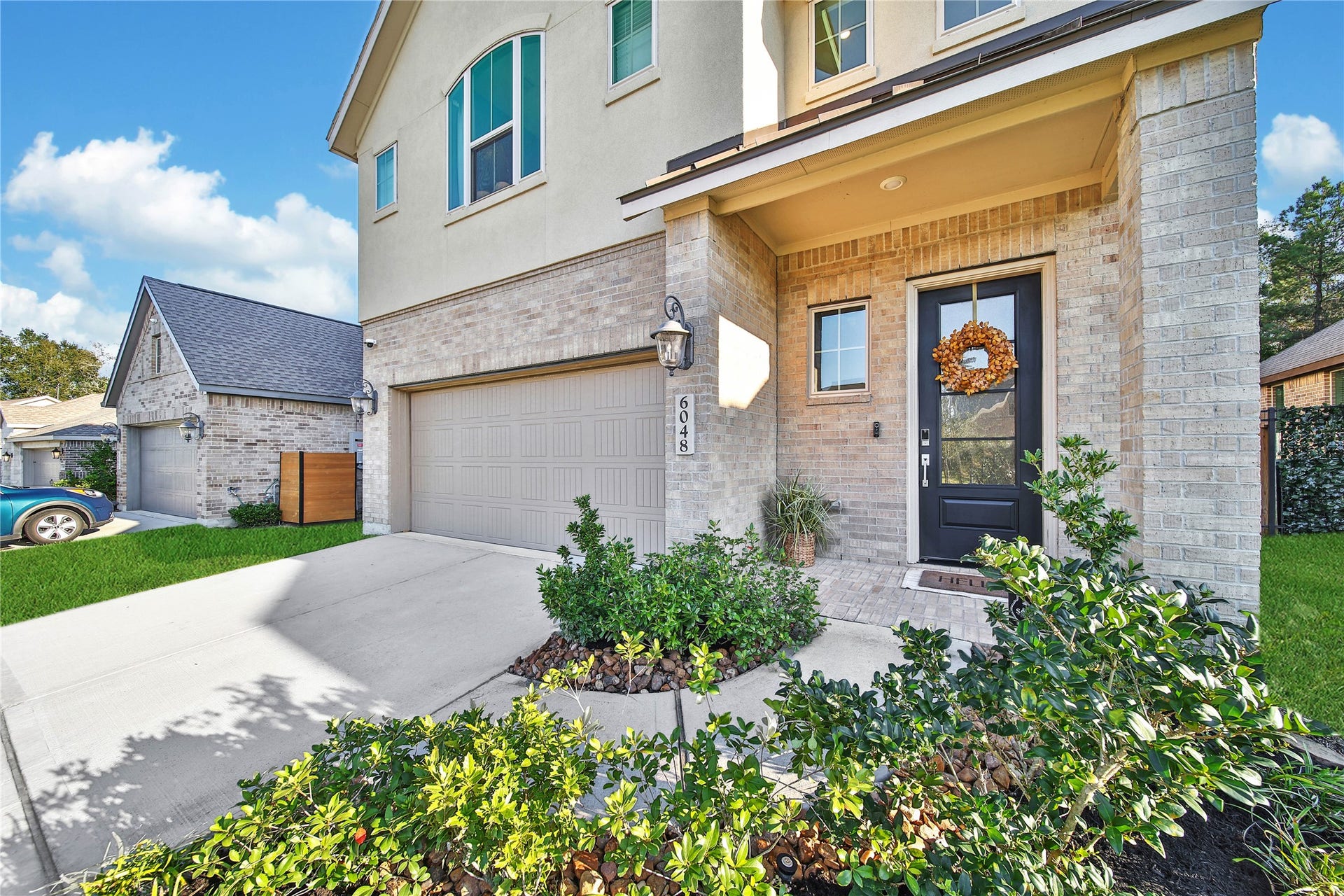 6048 Windward Falls Way, Porter, TX 77365 Welcoming front entry. Love the metal roof over the covered front porch! Sprinkler system keeps these beautiful plants and flowers alive. Gorgeous curb appeal!