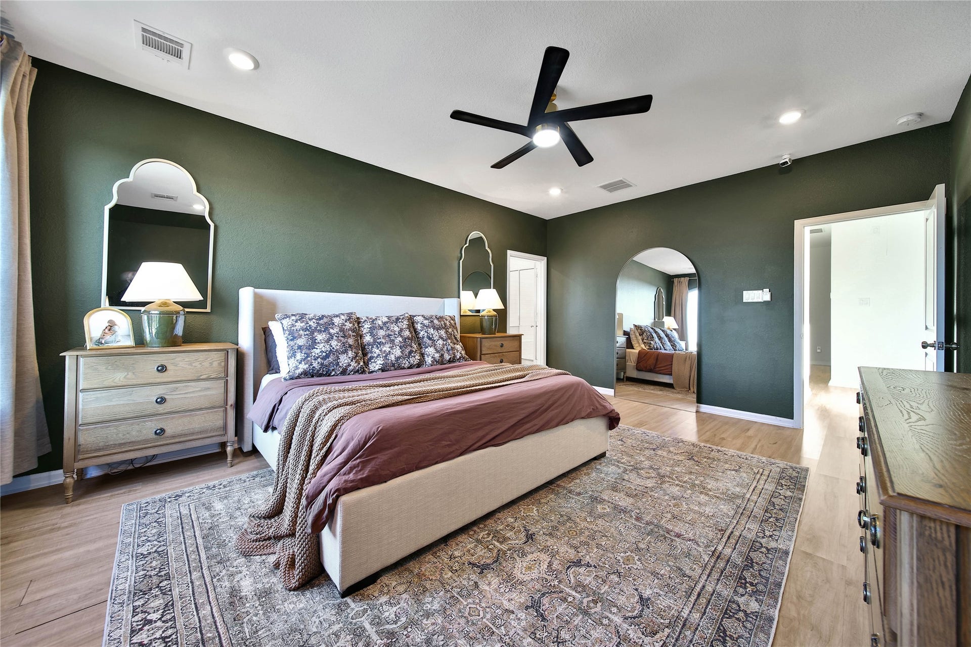 6048 Windward Falls Way, Porter, TX 77365 Laminate flooring in primary bedroom. Custom paint colors and upgraded ceiling fan really showcase this room.