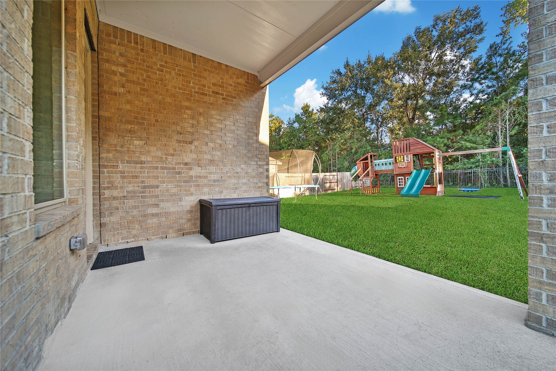 6048 Windward Falls Way, Porter, TX 77365 Fall is almost here! You can enjoy this covered back porch all year long. The kids will love this as the playground and the trampoline are included with the purchase of this home!