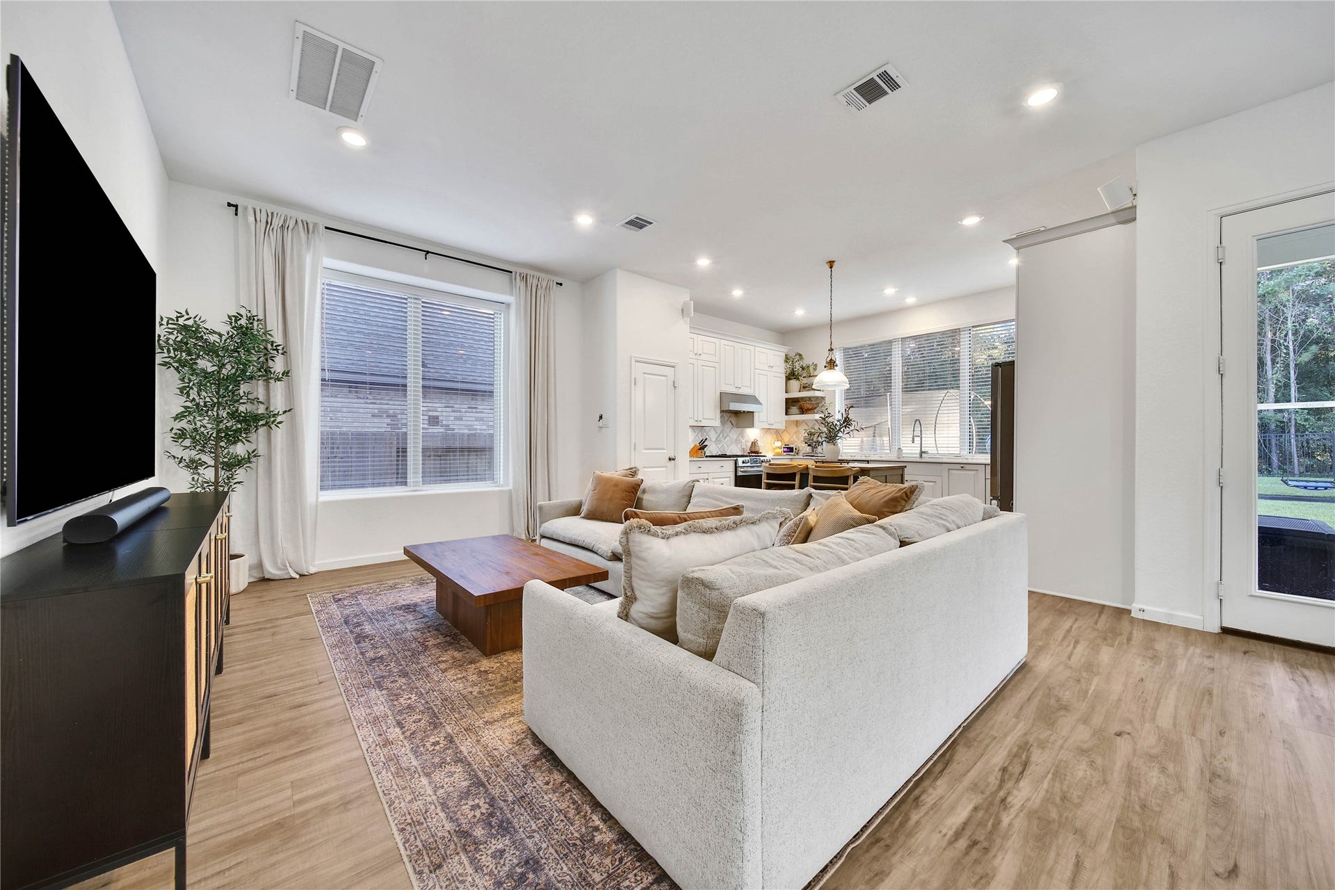 6048 Windward Falls Way, Porter, TX 77365 Windows, windows and more windows provide natural light throughout this entire area. Downstairs has laminate flooring throughout. Family room open to kitchen. This is a great floor plan!