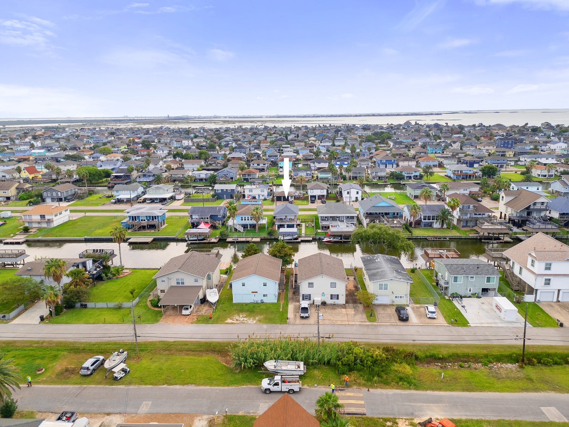66 Tarpon Street, Bayou Vista, TX 77563 Canal-side view featuring the covered boat slip, dock and waterfront access.