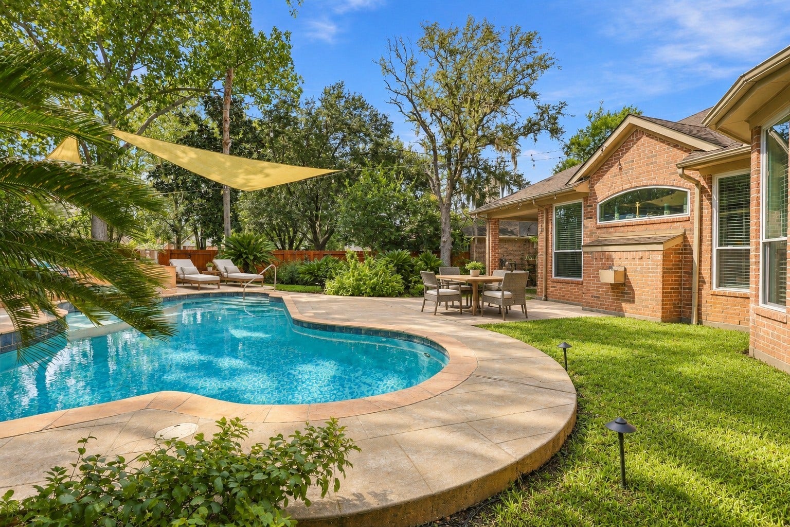 This angle highlights the connection between the pool and the home, with expansive rear windows, covered patio space, and lush landscaping.**Virtually staged