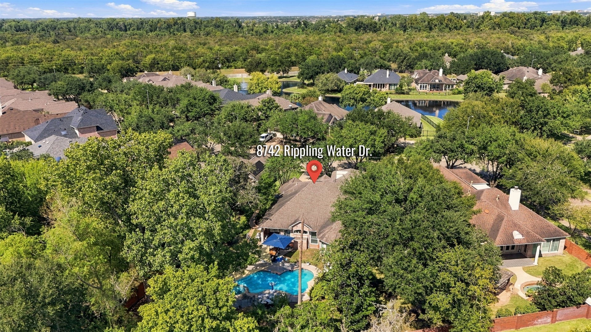 This elevated perspective highlights the homes location near scenic neighborhood water features and the expansive greenery found throughout the Greatwood community.