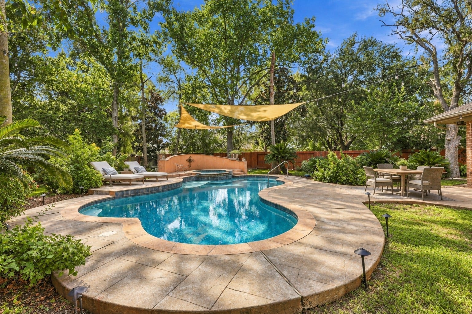 The resort-style backyard features a freeform pool with an adjoining HOT TUB, surrounded by mature trees, generous deck space, and inviting areas for outdoor enjoyment.**Virtually staged
