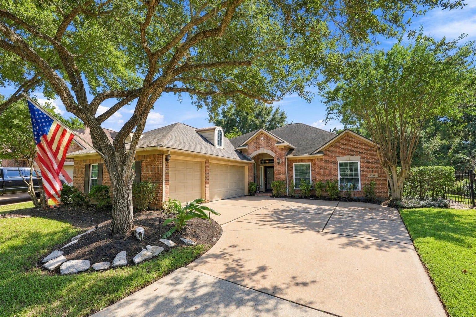 A wide driveway provides convenient access to the attached garage and front approach.